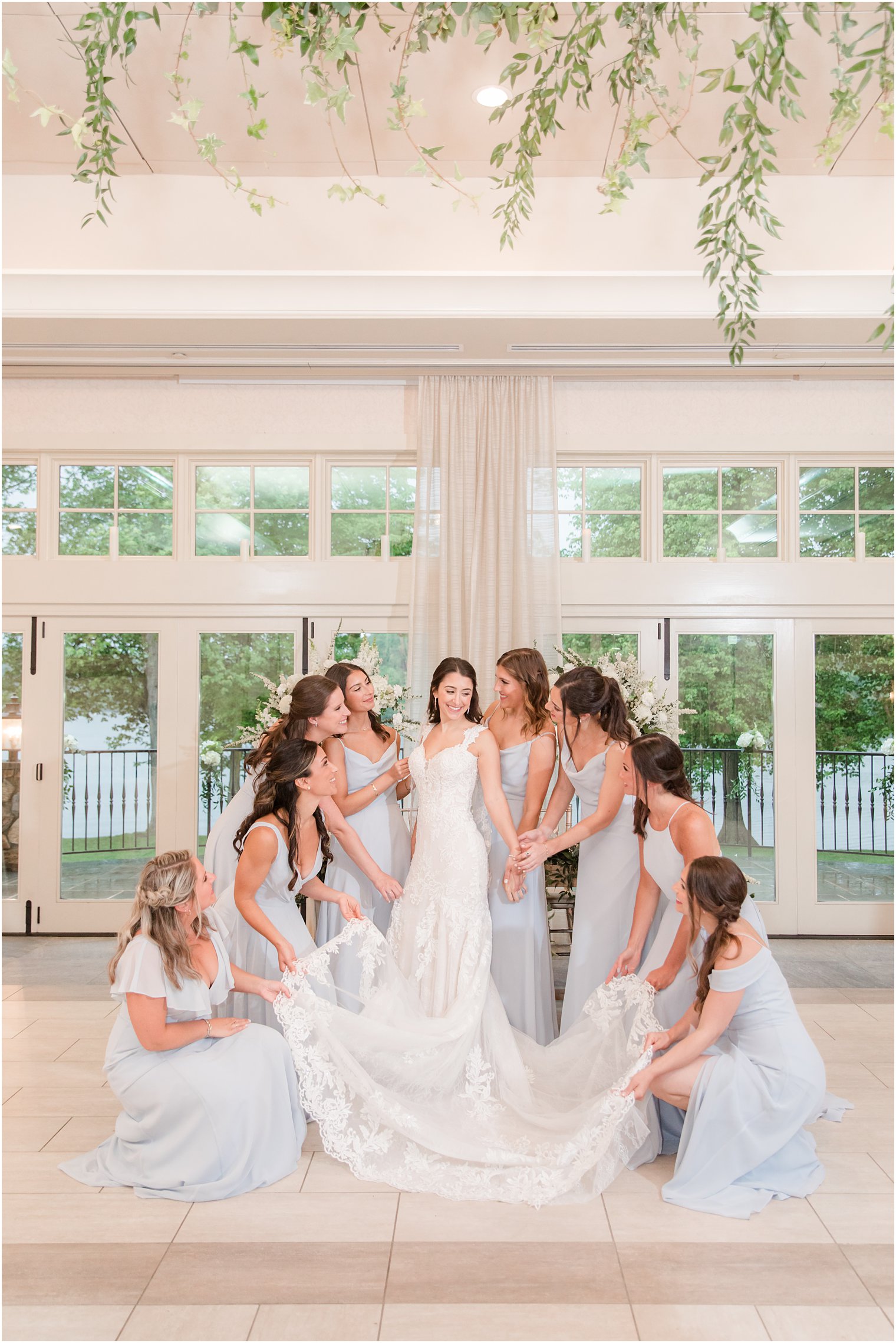 bridesmaids in pale blue gowns help bride with dress at Indian Trail Club