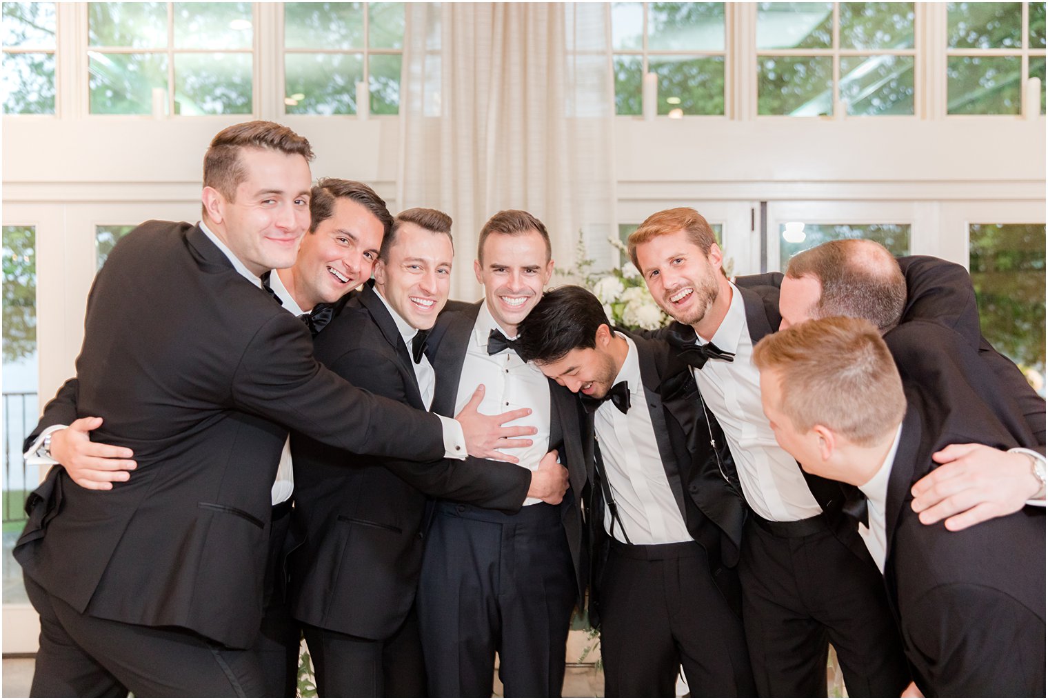 groom and groomsmen laugh together during photos at Indian Trail Club