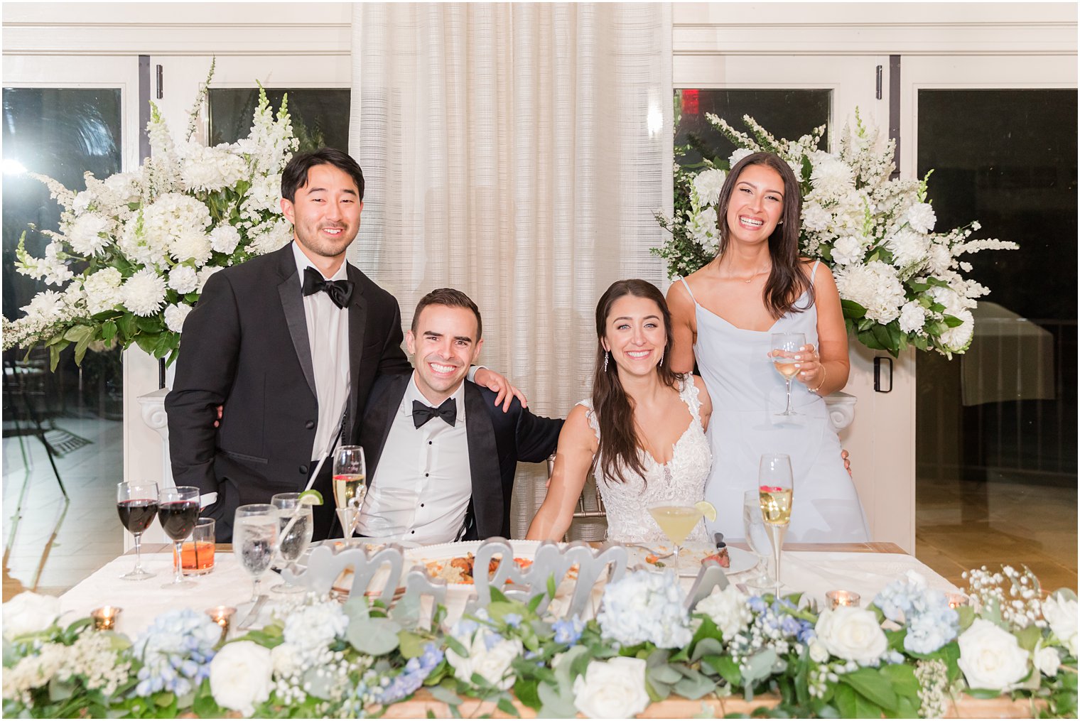 bride and groom sit with maid of honor and best man at NJ wedding reception