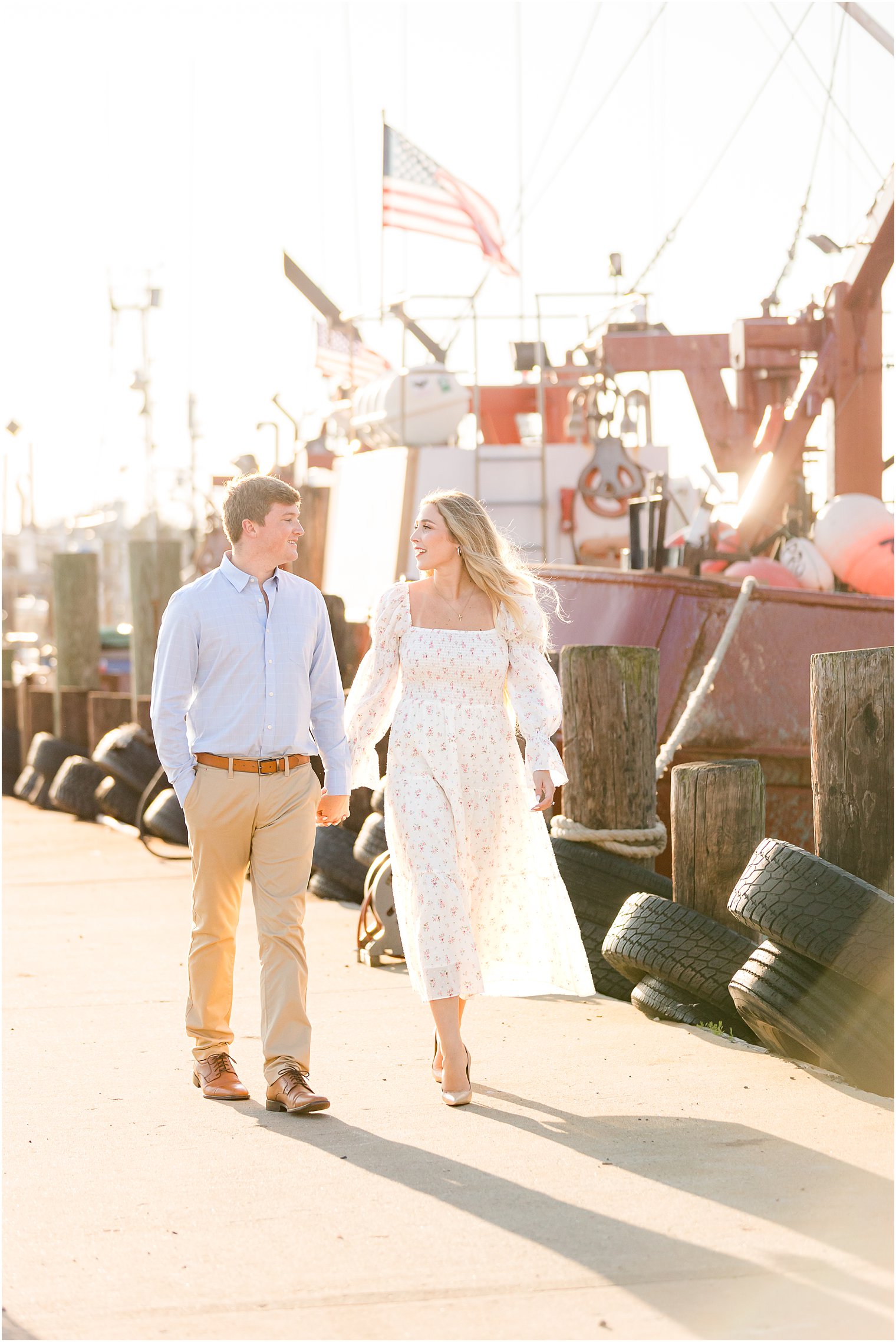 bride and groom hold hands walking down pier at Long Beach Island
