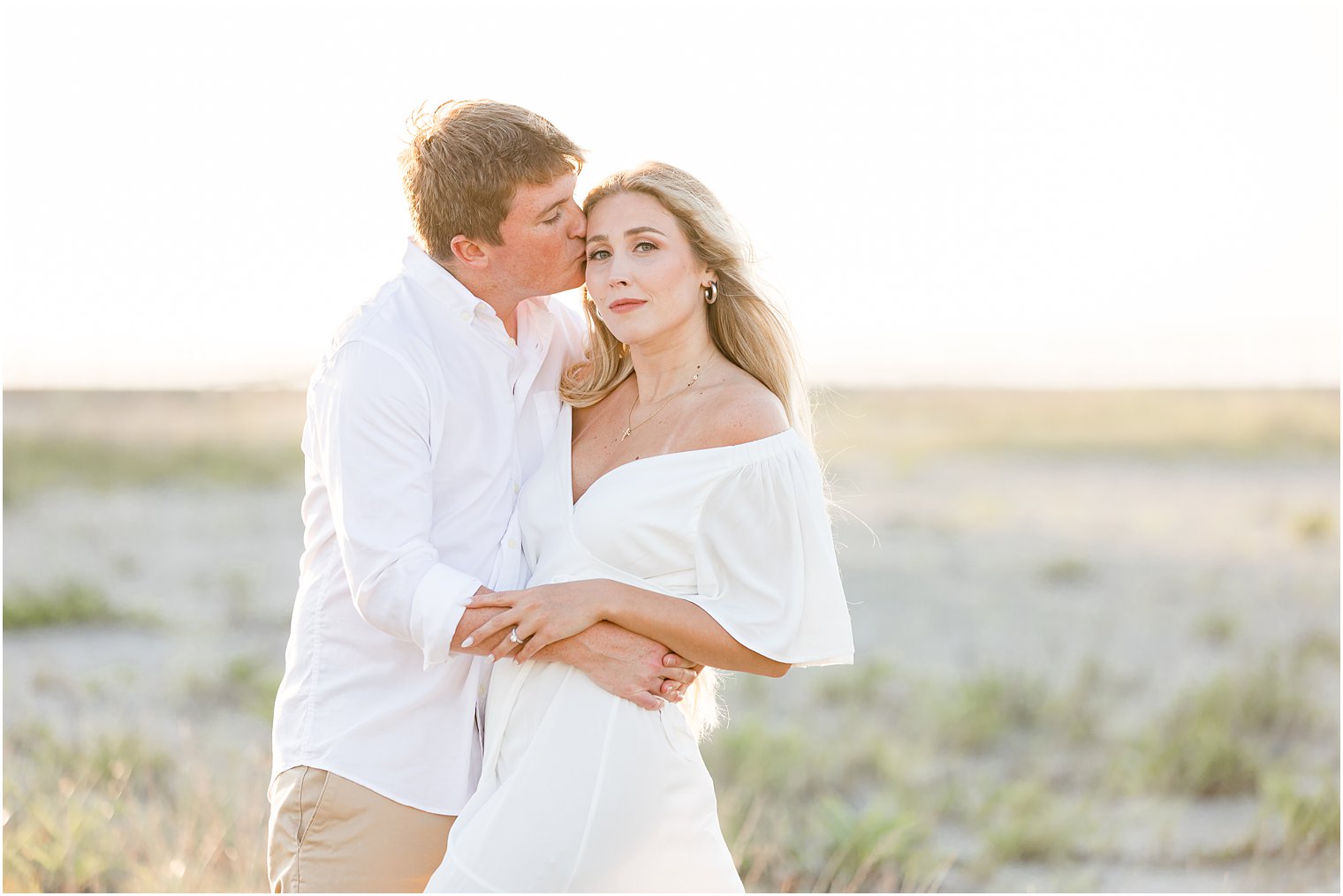 engaged couple hugs in marsh at Long Beach Island