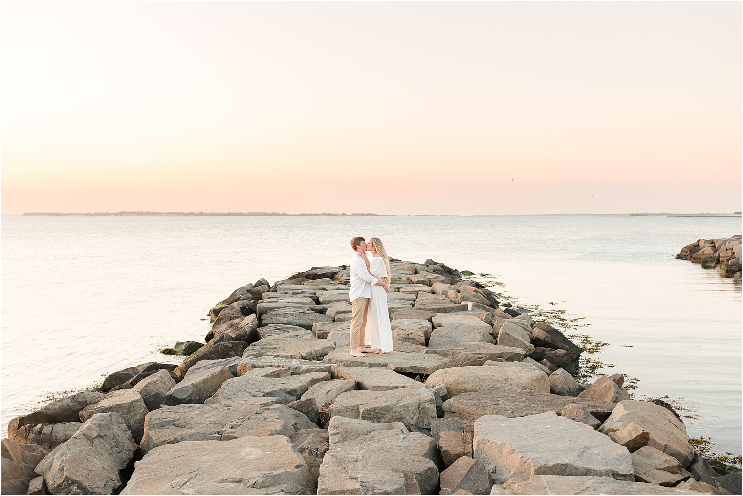 couple stand on rock formation in Long Beach