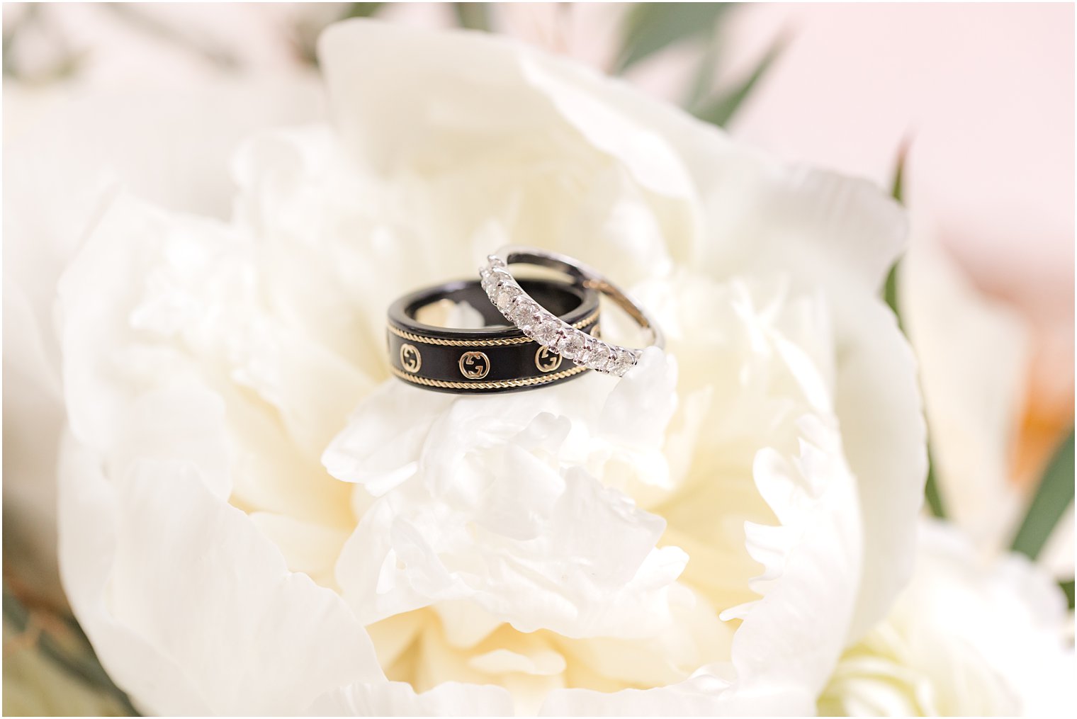 wedding rings rest on white peony