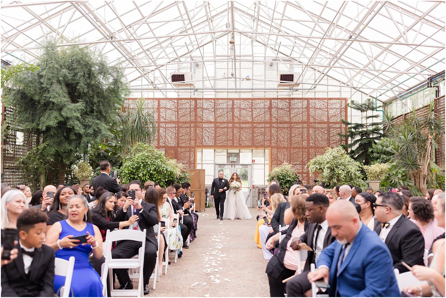 bride enters Fairmont Park Horticulture Center wedding ceremony with dad