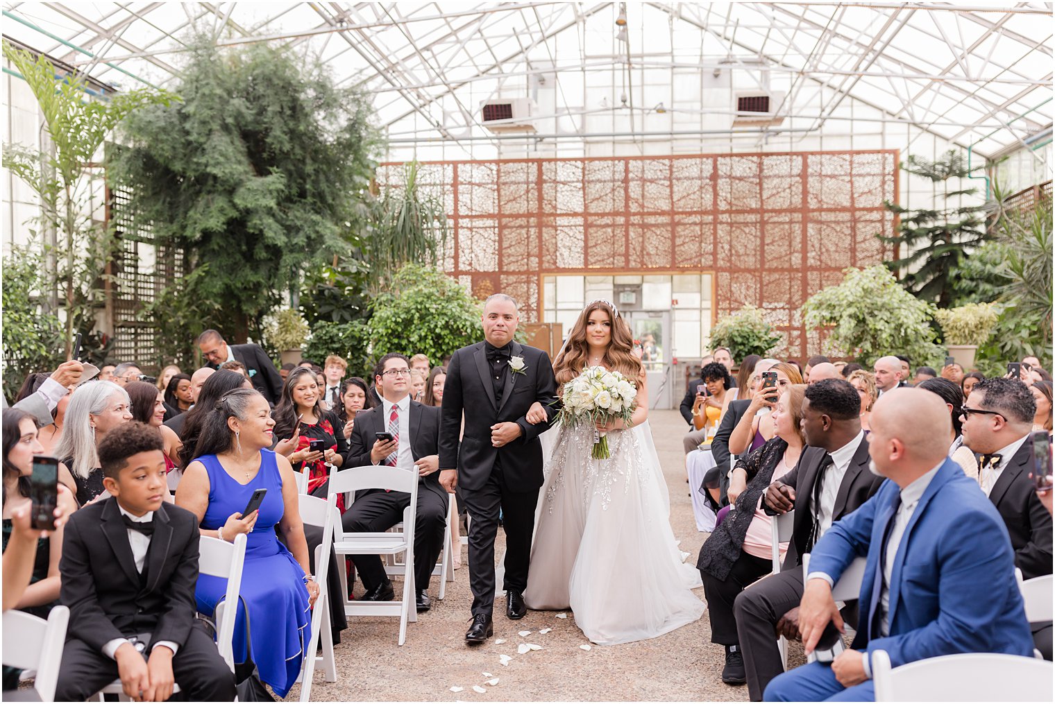bride and dad walk down aisle for Fairmont Park Horticulture Center wedding ceremony