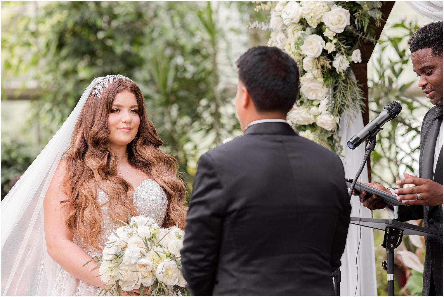 bride smiles at groom during Fairmont Park Horticulture Center wedding ceremony