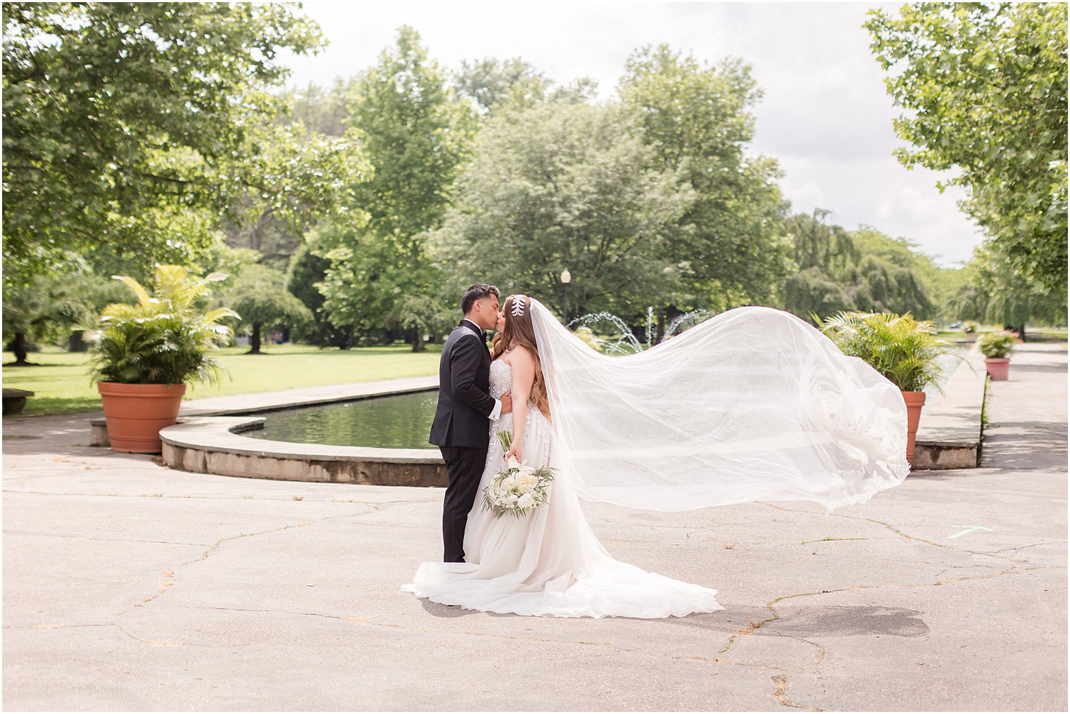 bride and groom kiss by fountain in Philadelphia PA