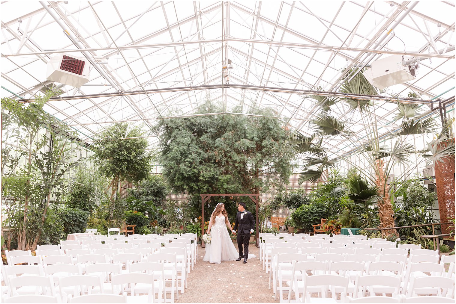 bride and groom walk through greenhouse at Fairmont Park Horticulture Center 