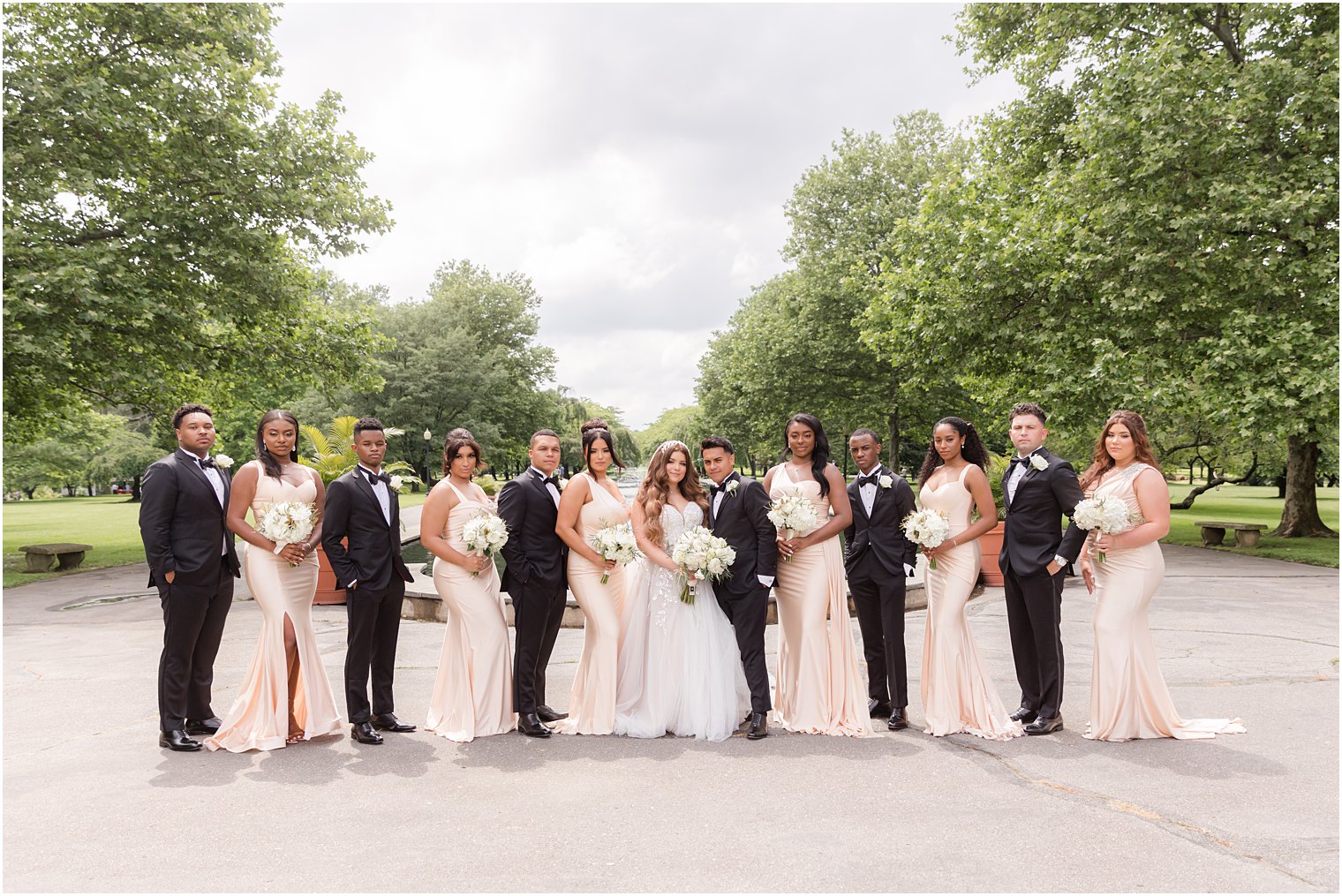 bride and groom stand with wedding party at Fairmount Park Horticulture Center