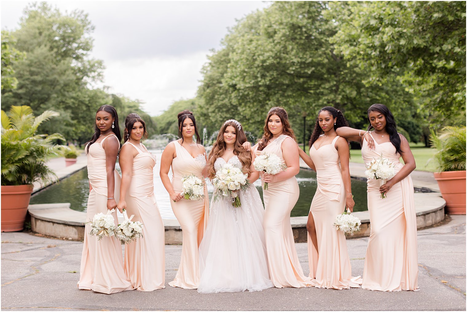 bride and bridesmaids pose by fountain at Fairmount Park Horticulture Center