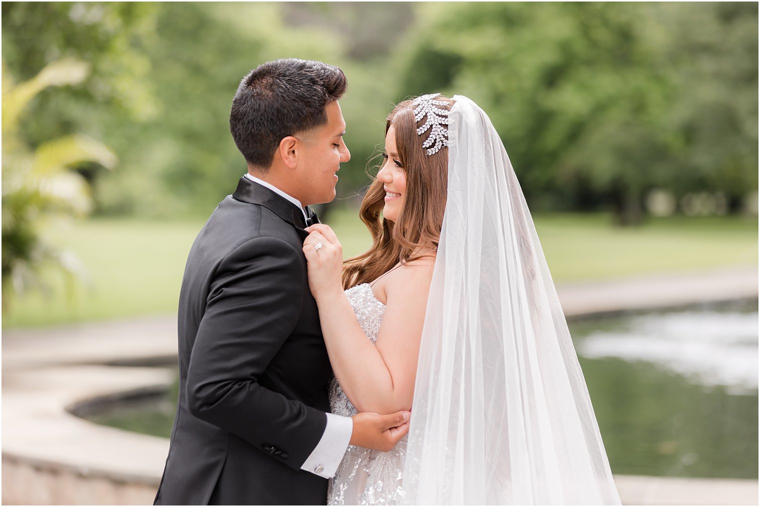 newlyweds dance smiling together by fountain at Fairmount Park Horticulture Center