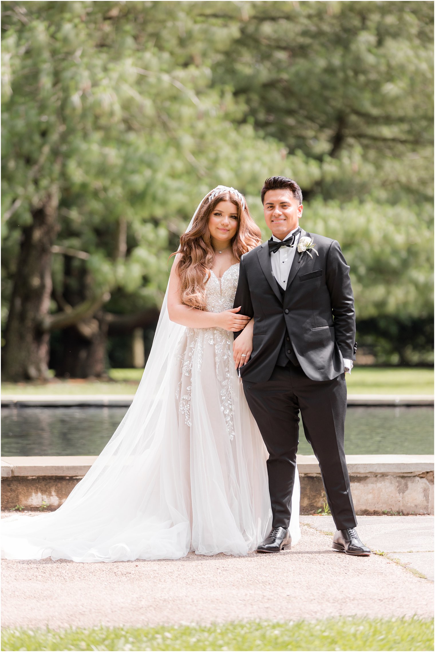 bride and groom stand by fountain at Fairmount Park Horticulture Center