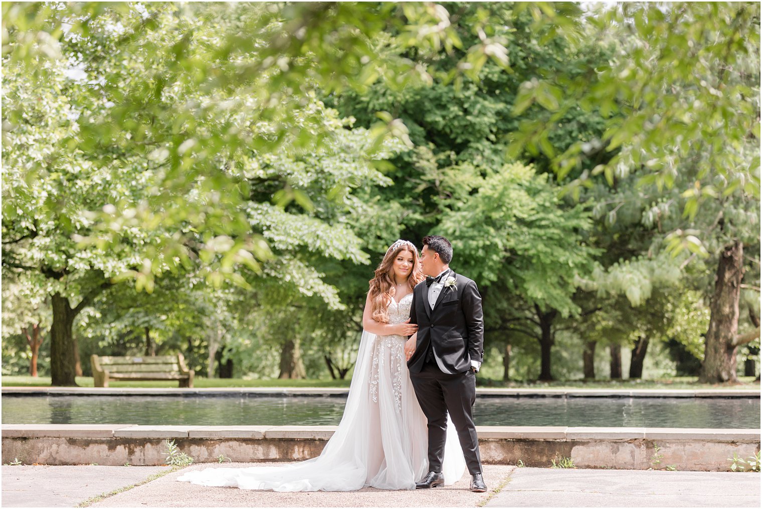 newlyweds stand by fountain in Fairmount Park Horticulture Center