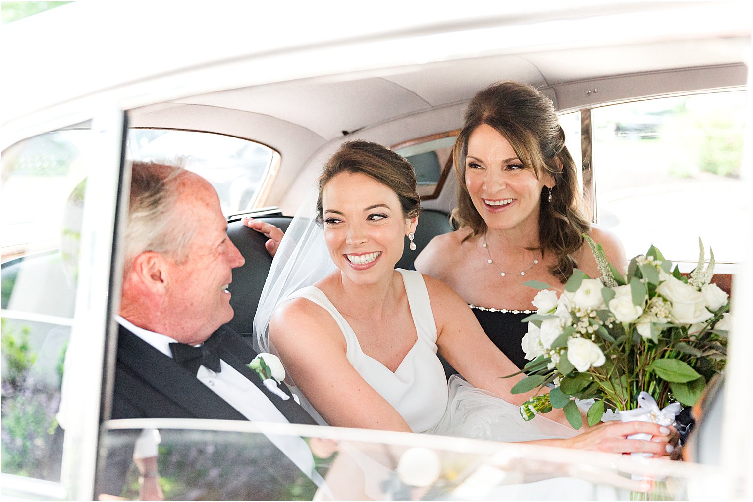 bride pulls up to wedding day with parents in classic car