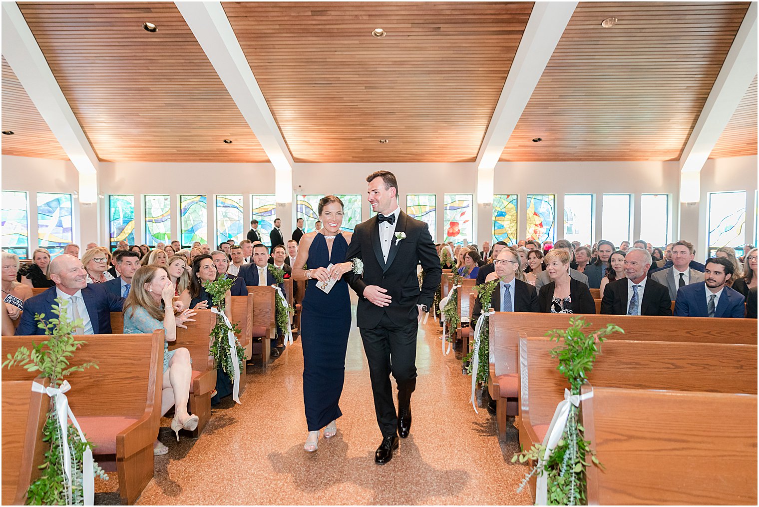 groom and mom walk down aisle at St. Joseph Roman Catholic Church