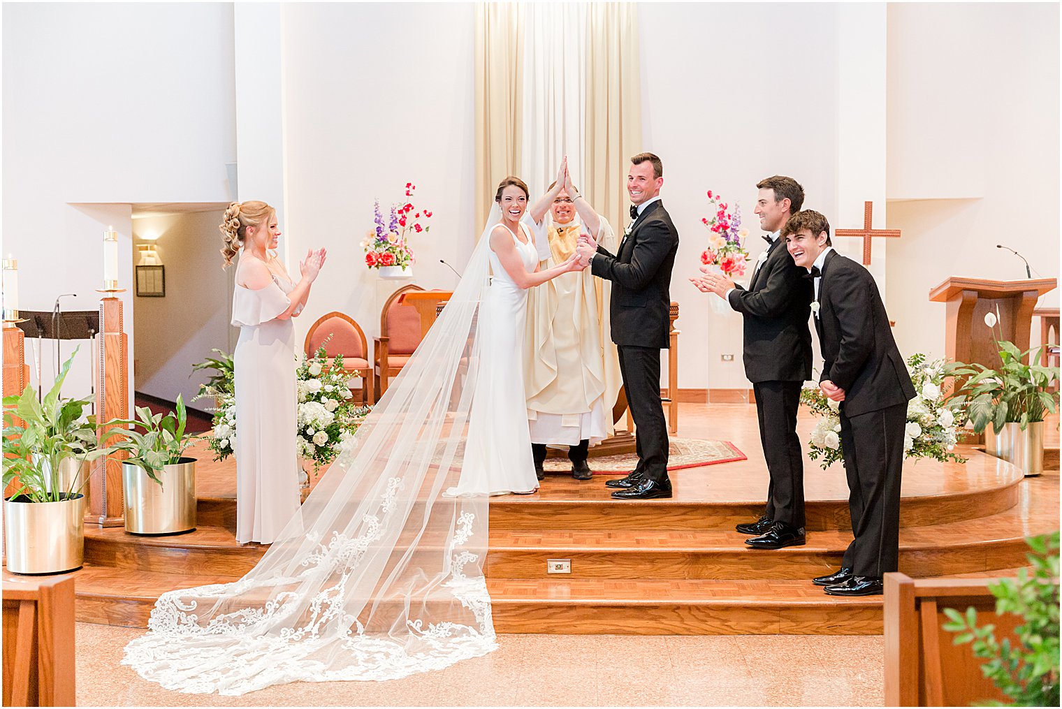 couple holds hands on steps during traditional ceremony at St.Joseph Roman Catholic Church