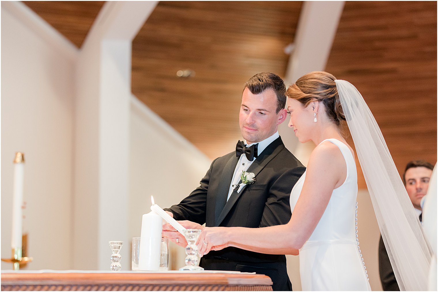 couple lights candles during traditional ceremony at St.Joseph Roman Catholic Church