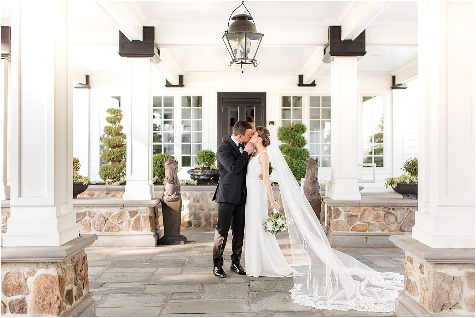 newlyweds kiss during portraits at Ryland Inn