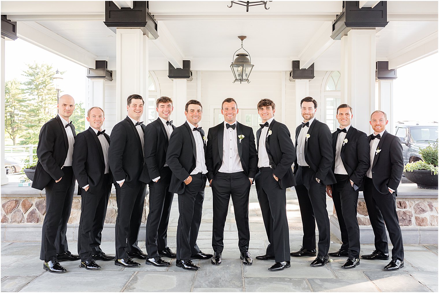 groom poses with groomsmen in classic tuxes at Ryland Inn