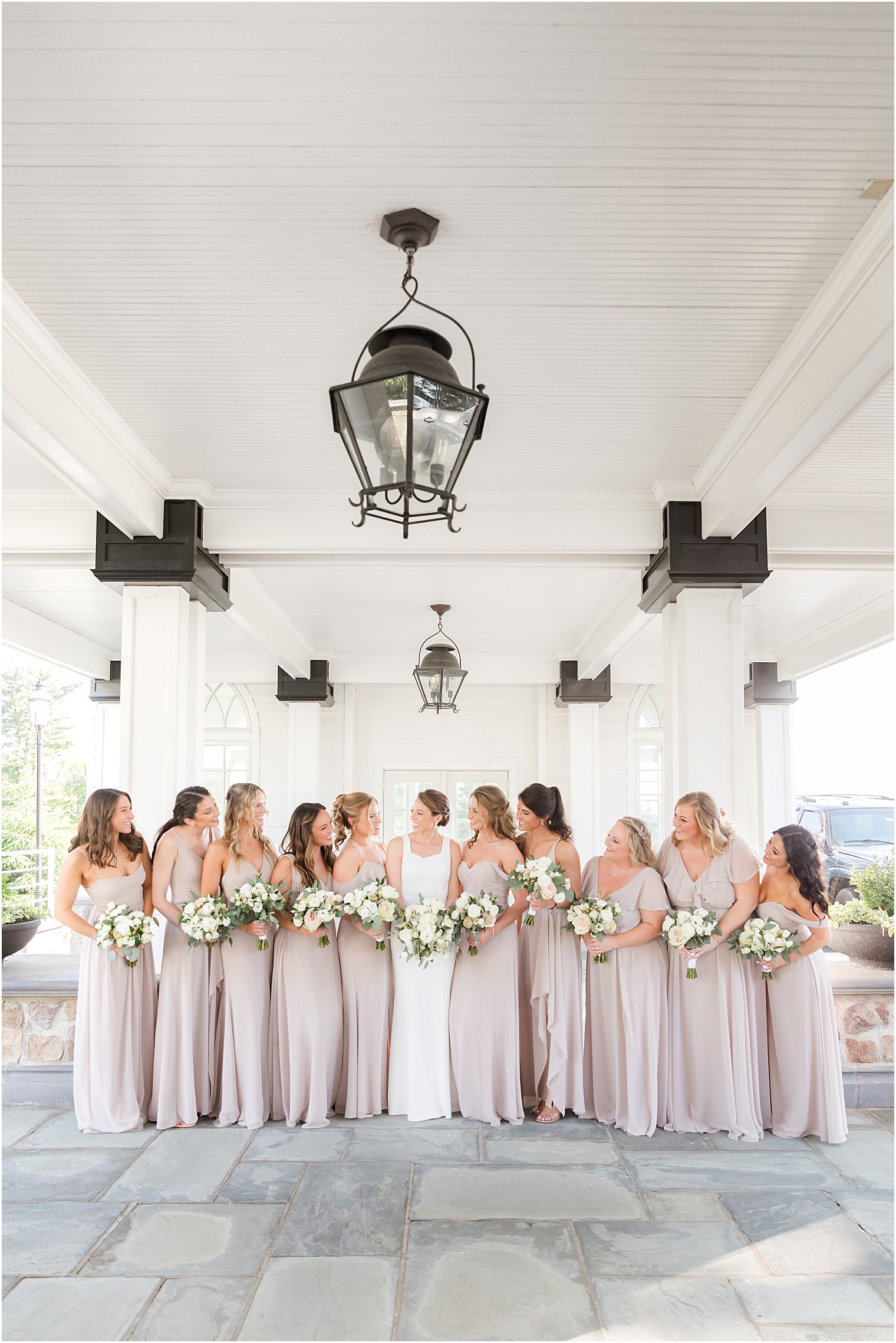 bride and bridesmaids pose in pink pastel gowns outside Ryland Inn