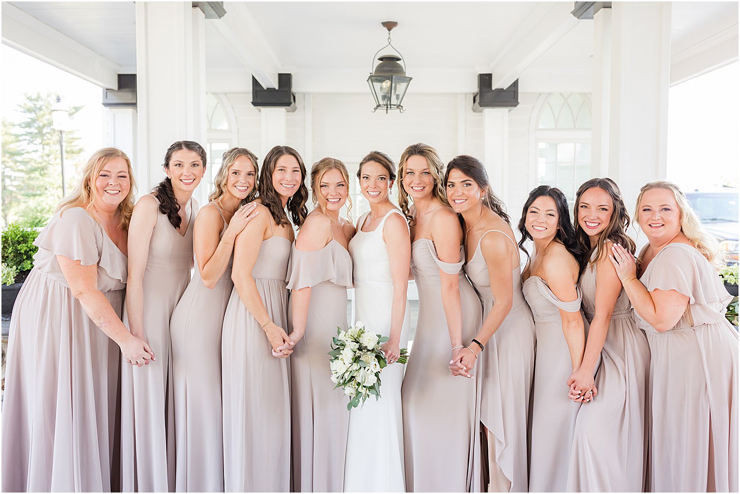 bridesmaids hug bride outside Ryland Inn