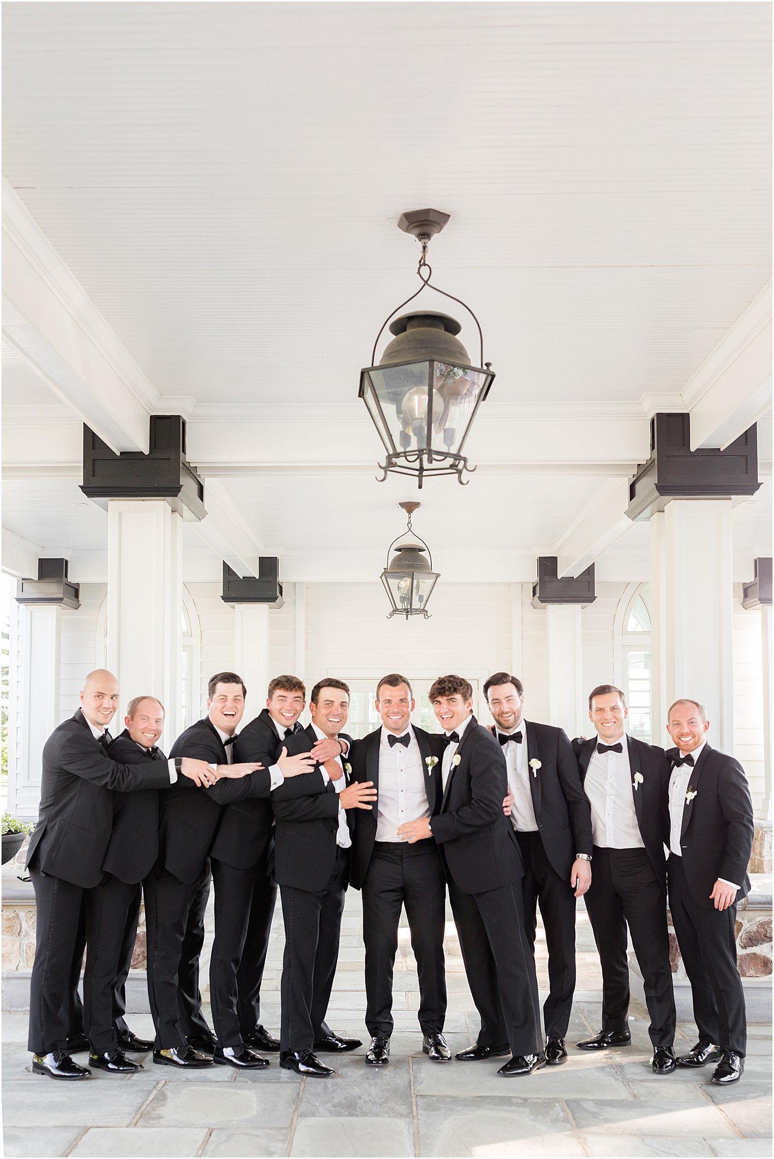 groom stands with groomsmen in tux