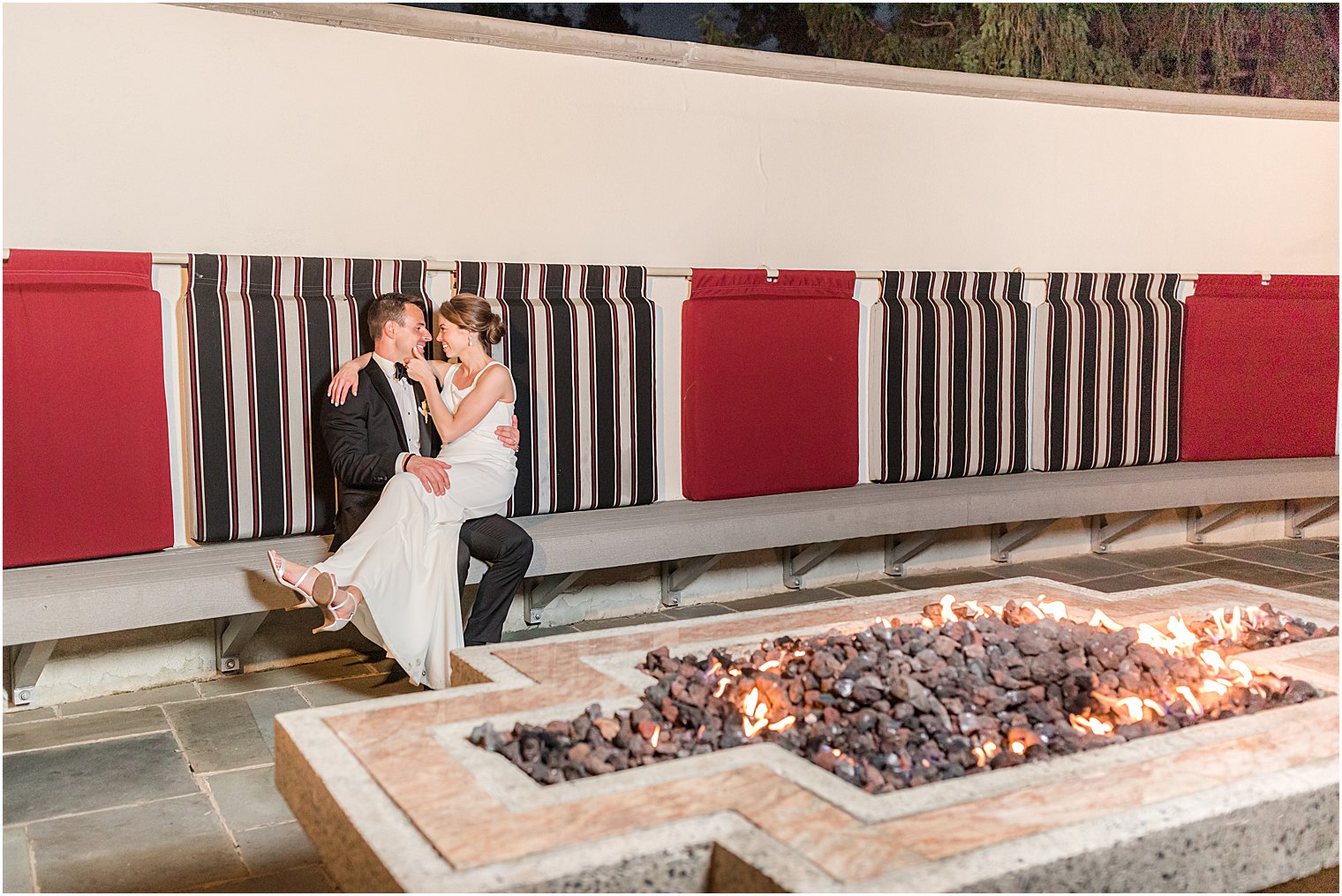 bride and groom sit by fire at Ryland Inn