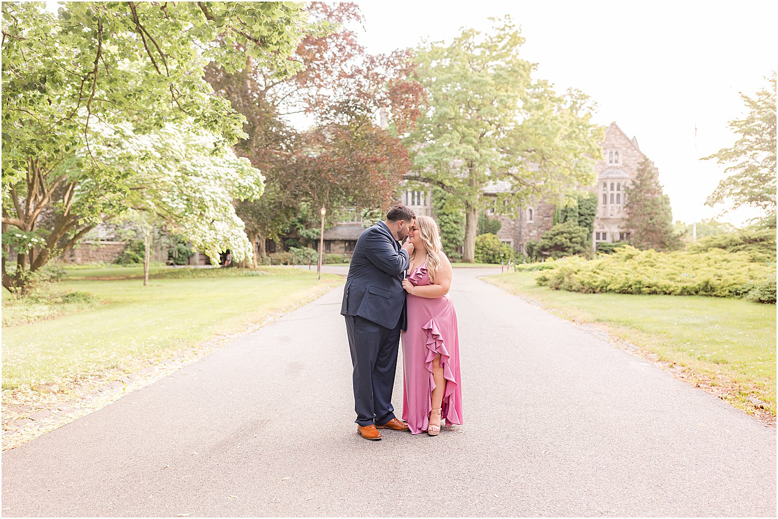 bride and groom kiss on driveway during summertime Skylands Manor engagement session