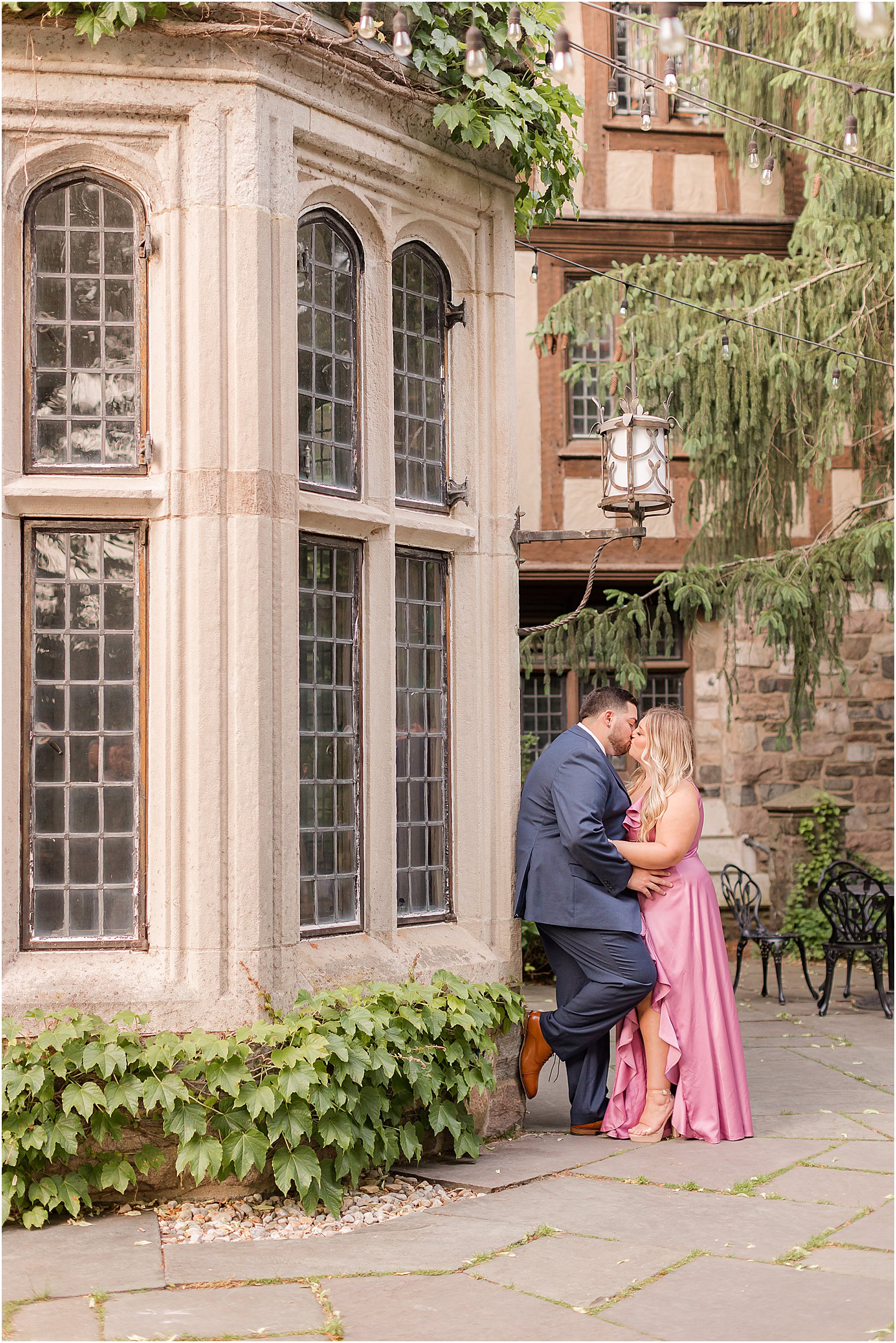 bride and groom kiss by ivy covered wall during summertime Skylands Manor engagement session