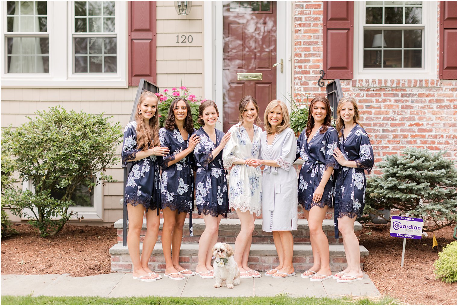 bride and bridesmaids pose outside NJ home in matching robes 