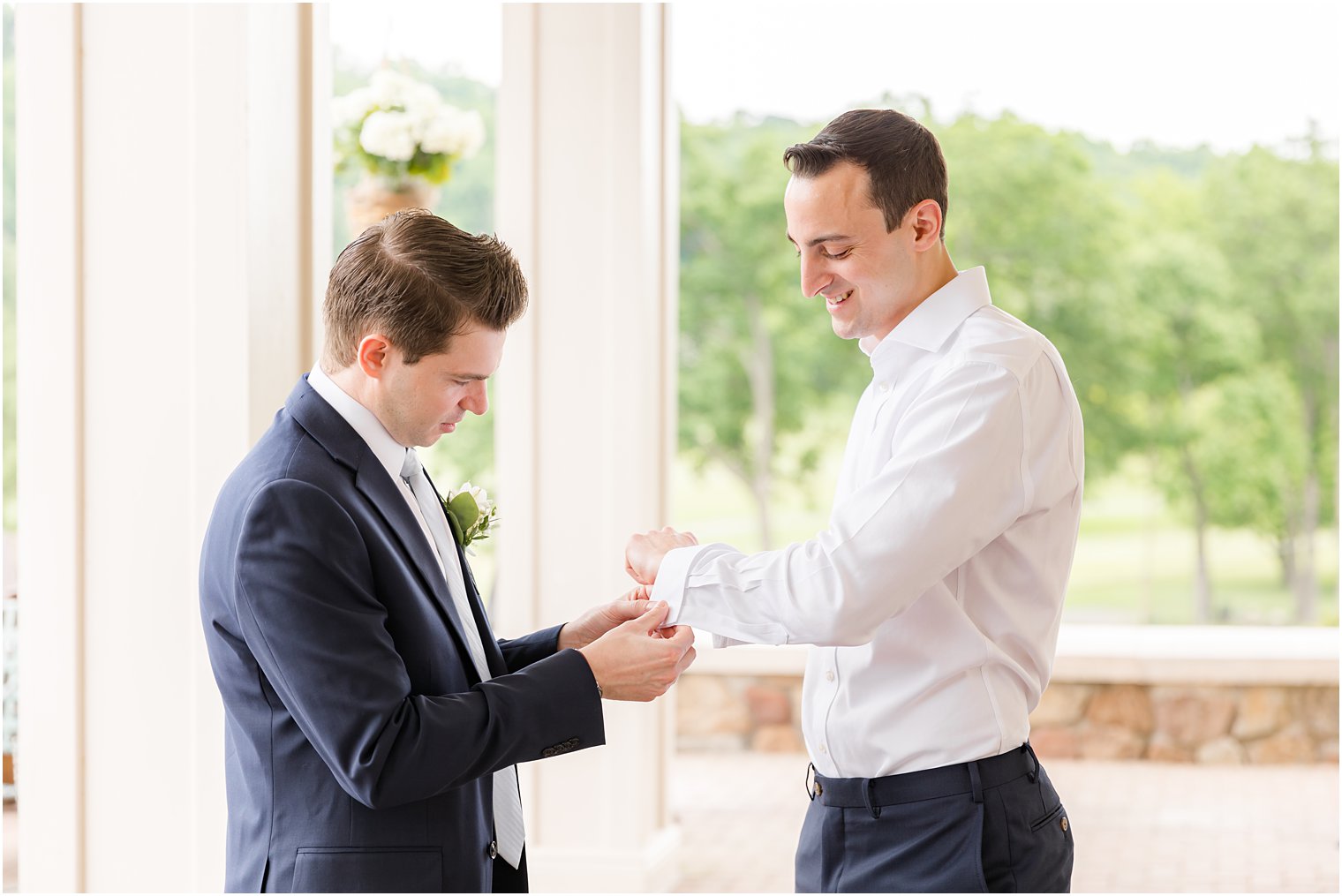 groomsman helps groom with custom cufflinks