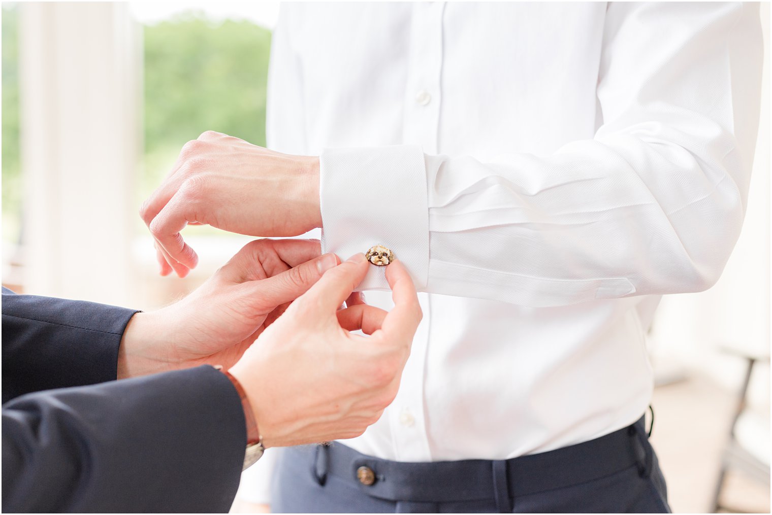 groom shows off cufflinks before Spring Brook Country Club wedding