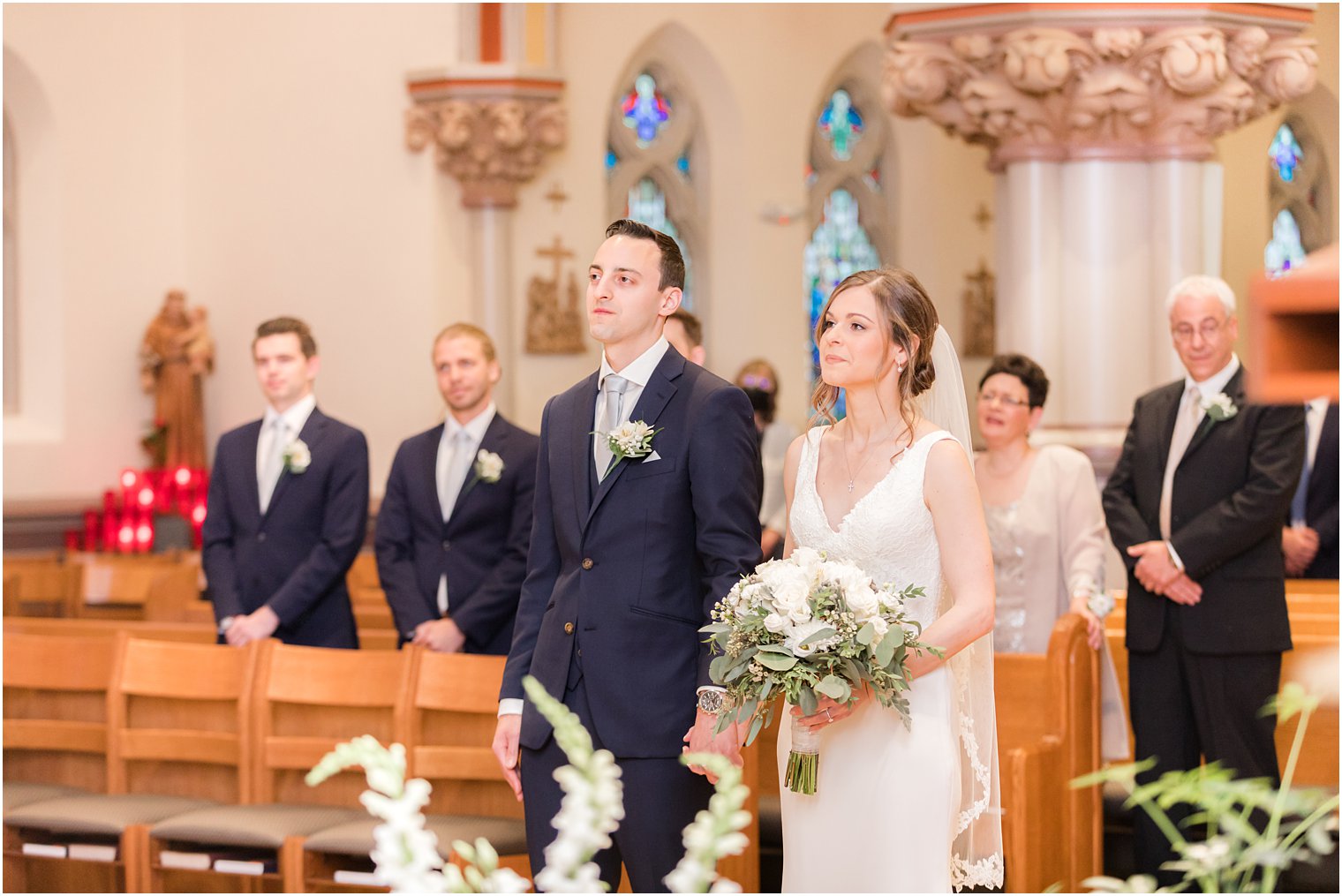 bride and groom stand together during traditional ceremony at St. Vincent Martyr Church