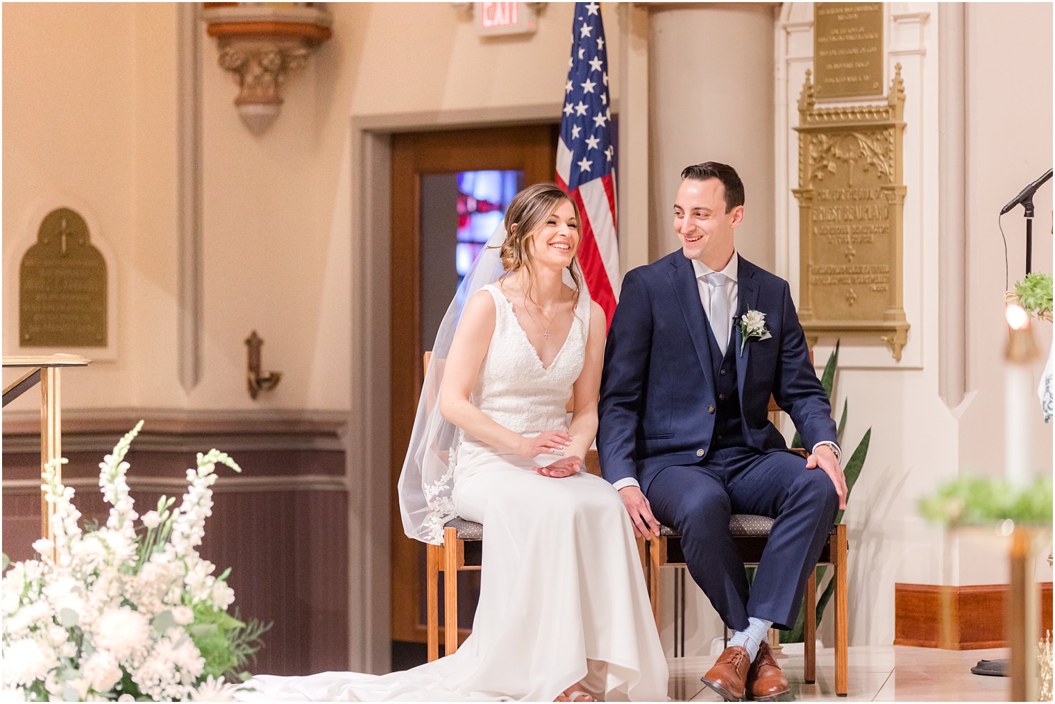 bride and groom laugh sitting together during wedding ceremony at St. Vincent Martyr Church