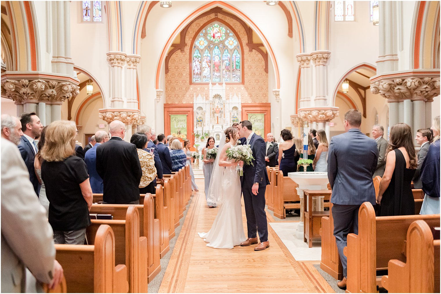 newlyweds kiss in aisle of St. Vincent Martyr Church after ceremony