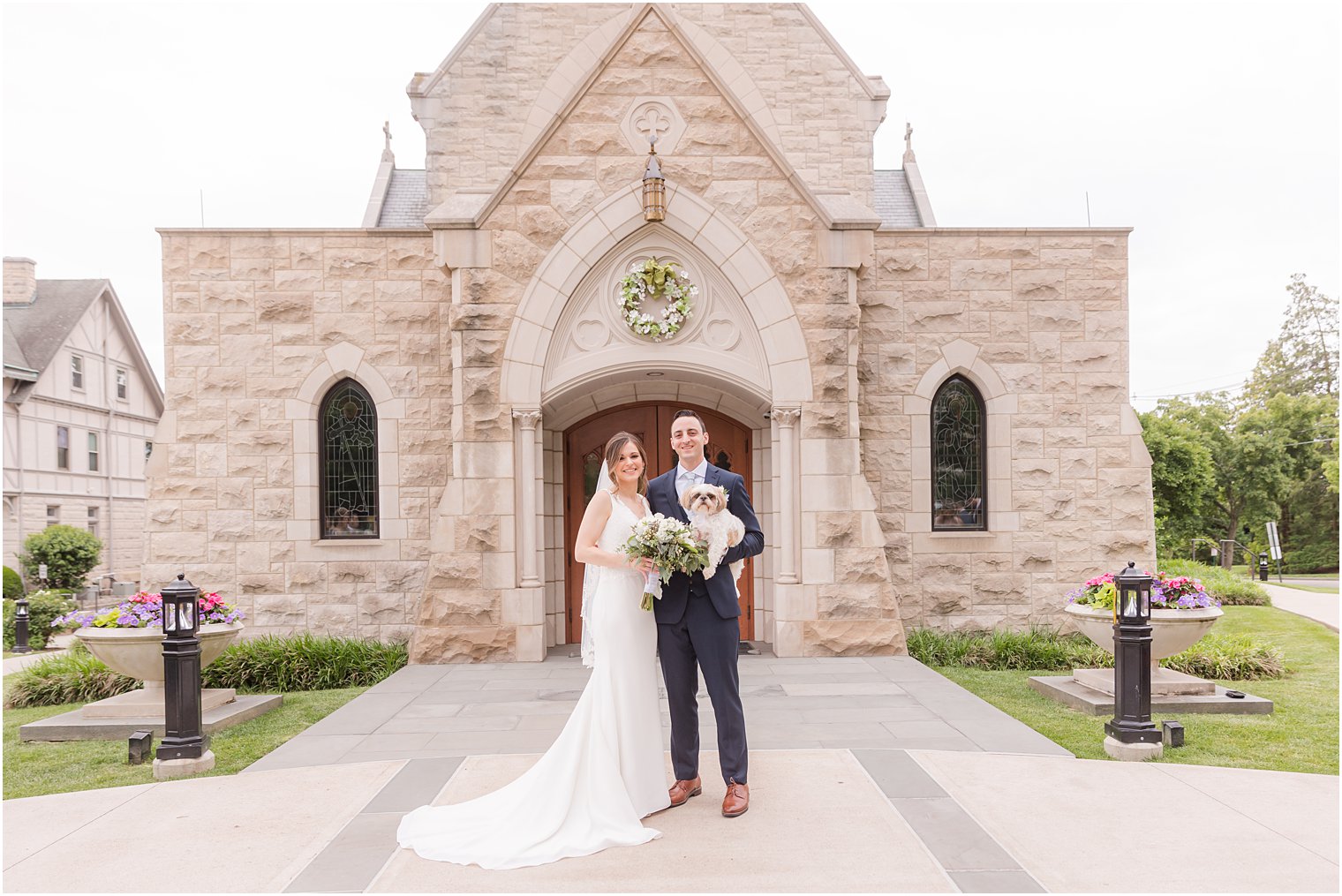 bride and groom stand with dog outside St. Vincent Martyr Church