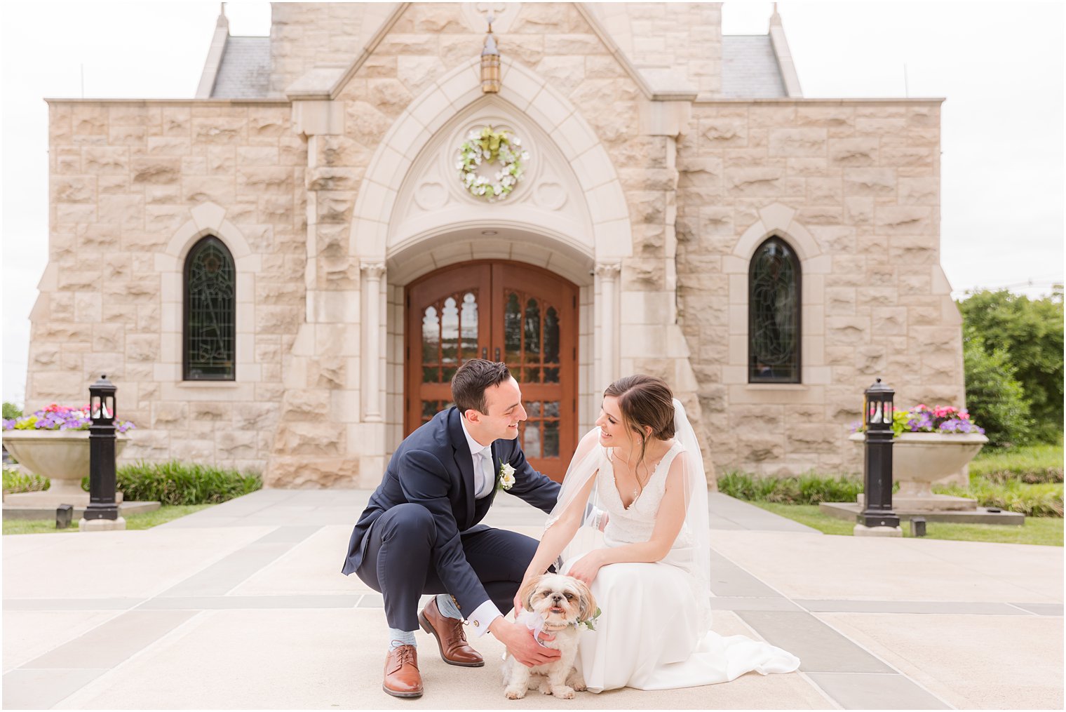 bride and groom smile during wedding portraits outside St. Vincent Martyr Church with dog 