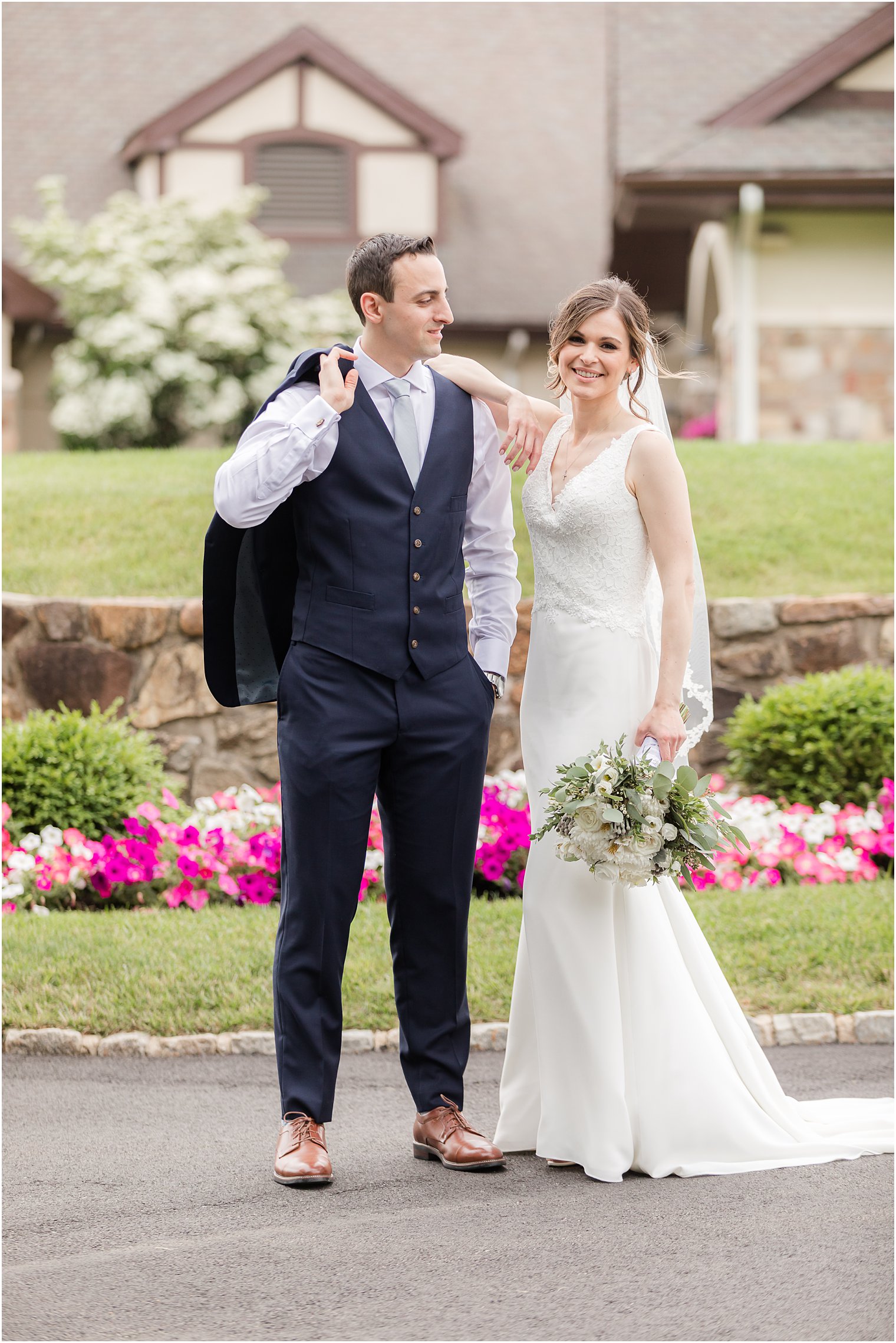 bride leans against groom's shoulder out front of Spring Brook Country Club