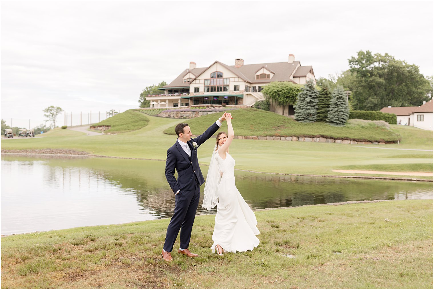groom twirls bride along lake at Spring Brook Country Club