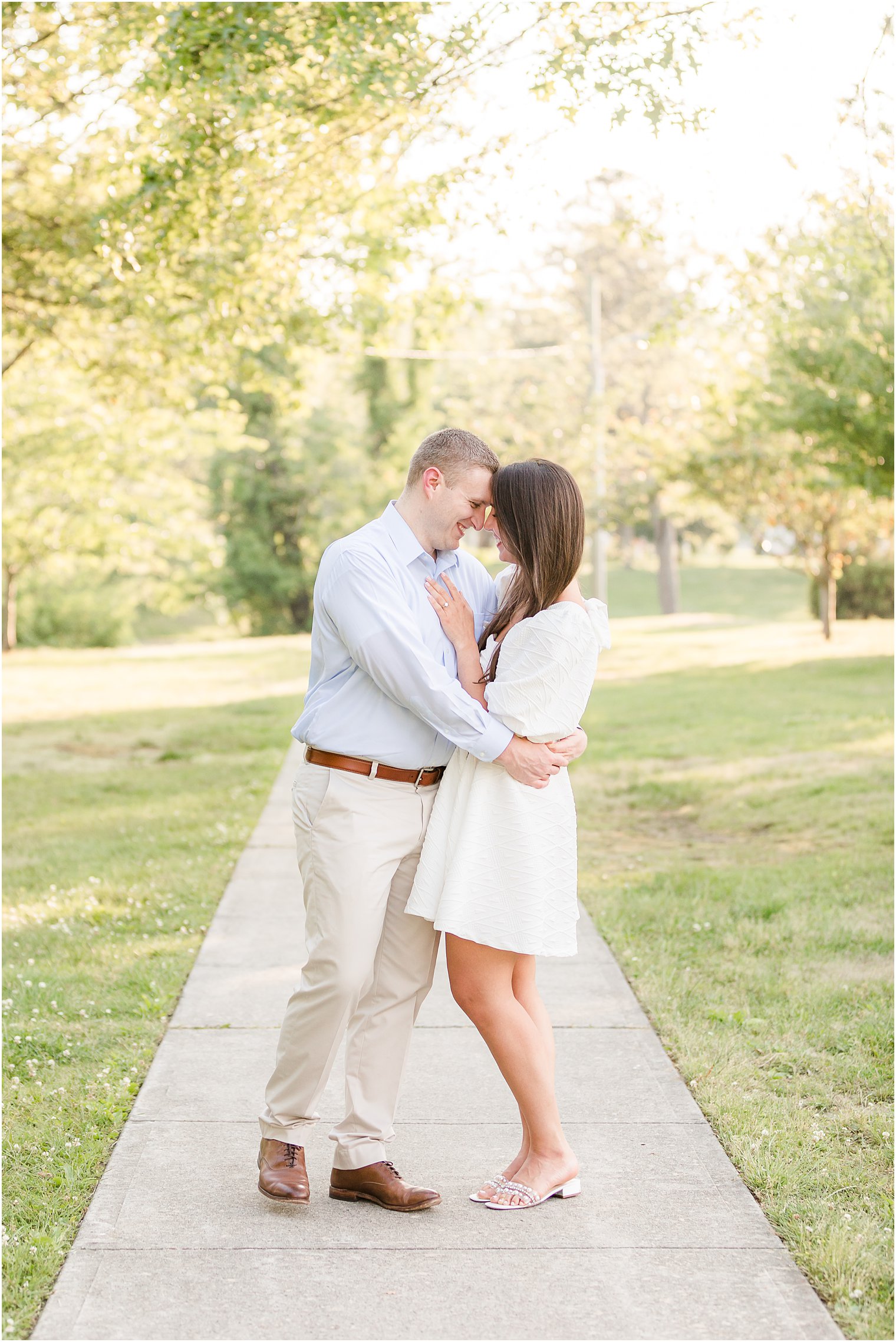 engaged couple stands with foreheads touching during Spring Lake engagement session