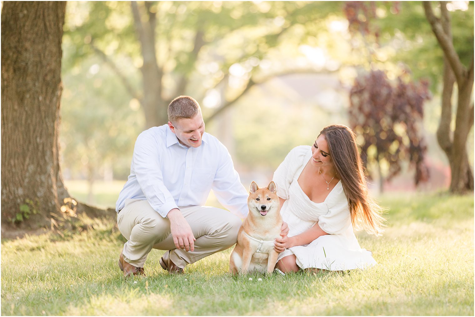 engaged couple kneels with dog during Spring Lake engagement session