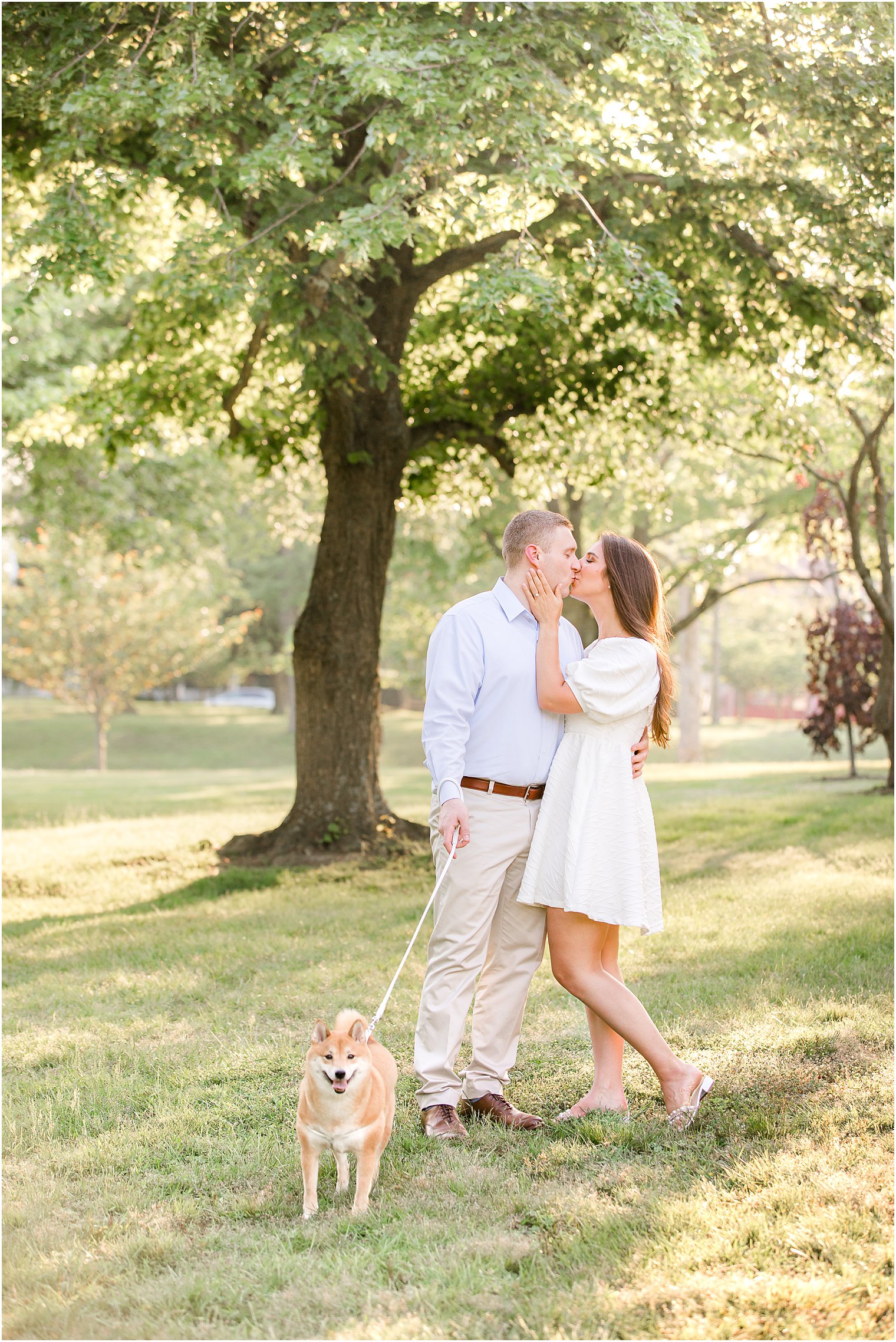 couple poses in Spring Lake Park with dog on leash by them