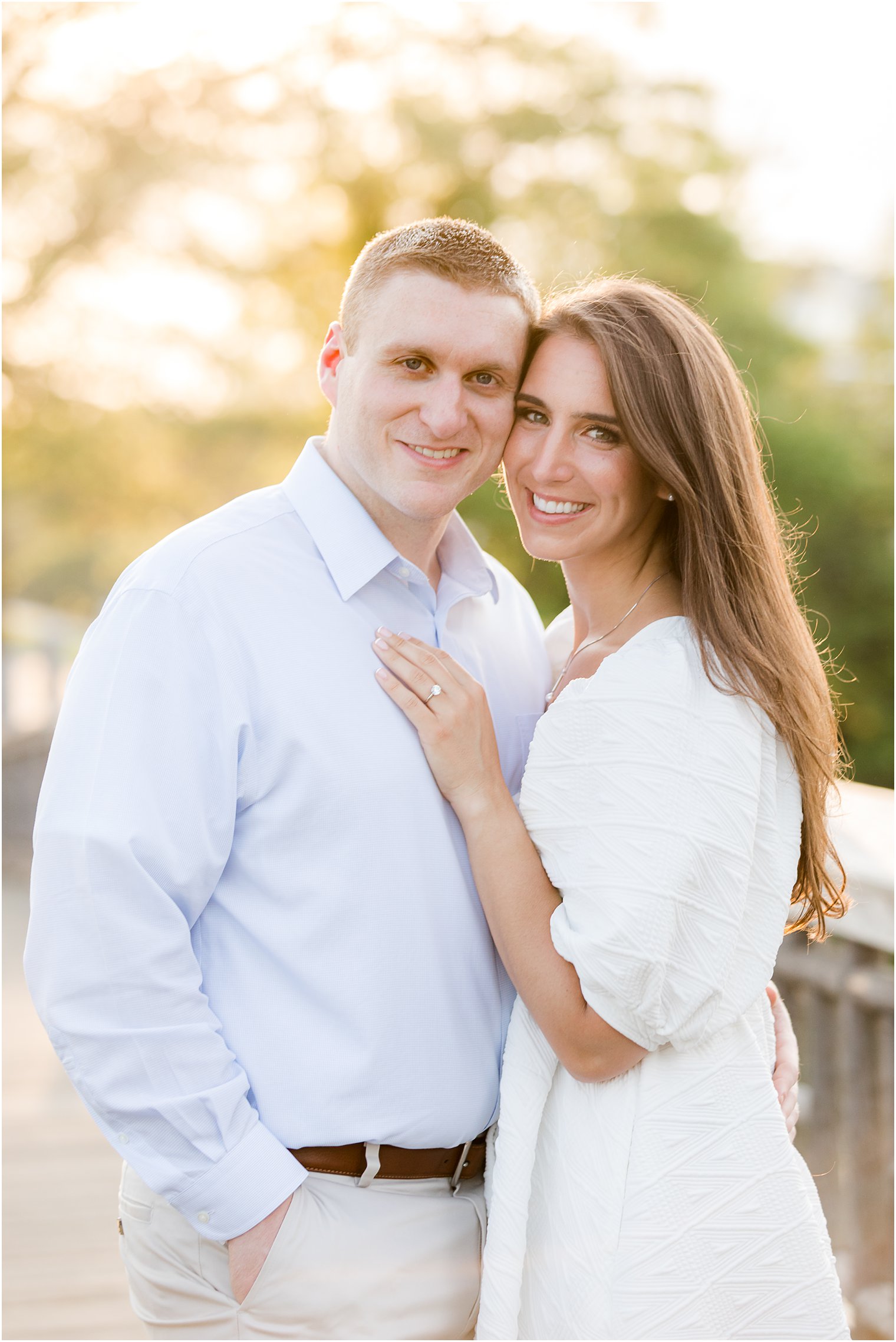 engaged couple stands on bridge during Spring Lake engagement session