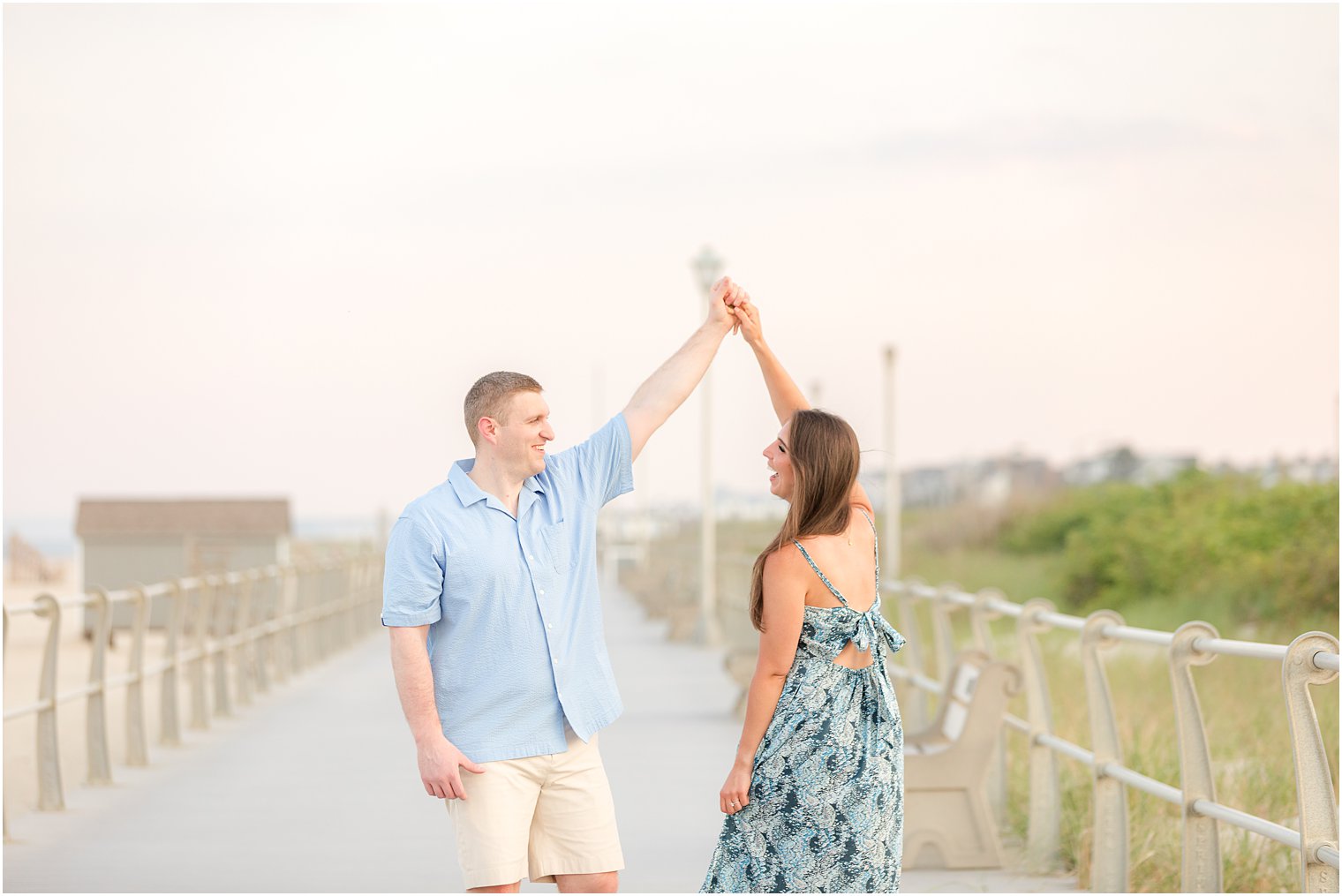 groom twirls bride on boardwalk in Spring Lake NJ