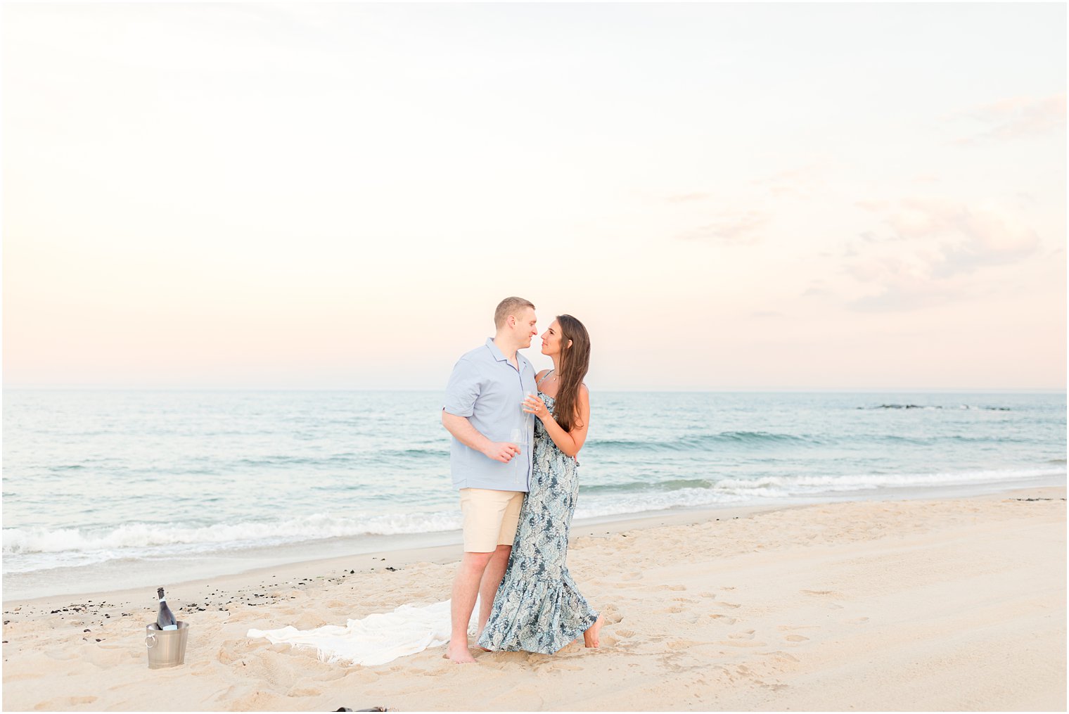 couple stands on beach during sunset in Spring Lake NJ