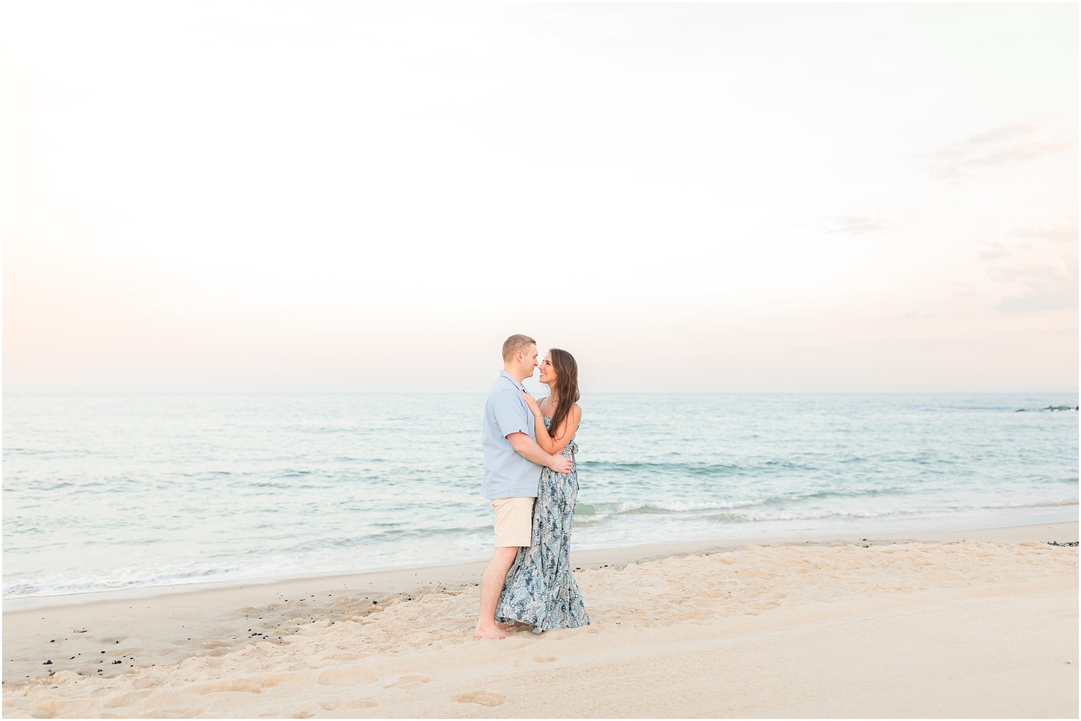 bride and groom hug at sunset on beach