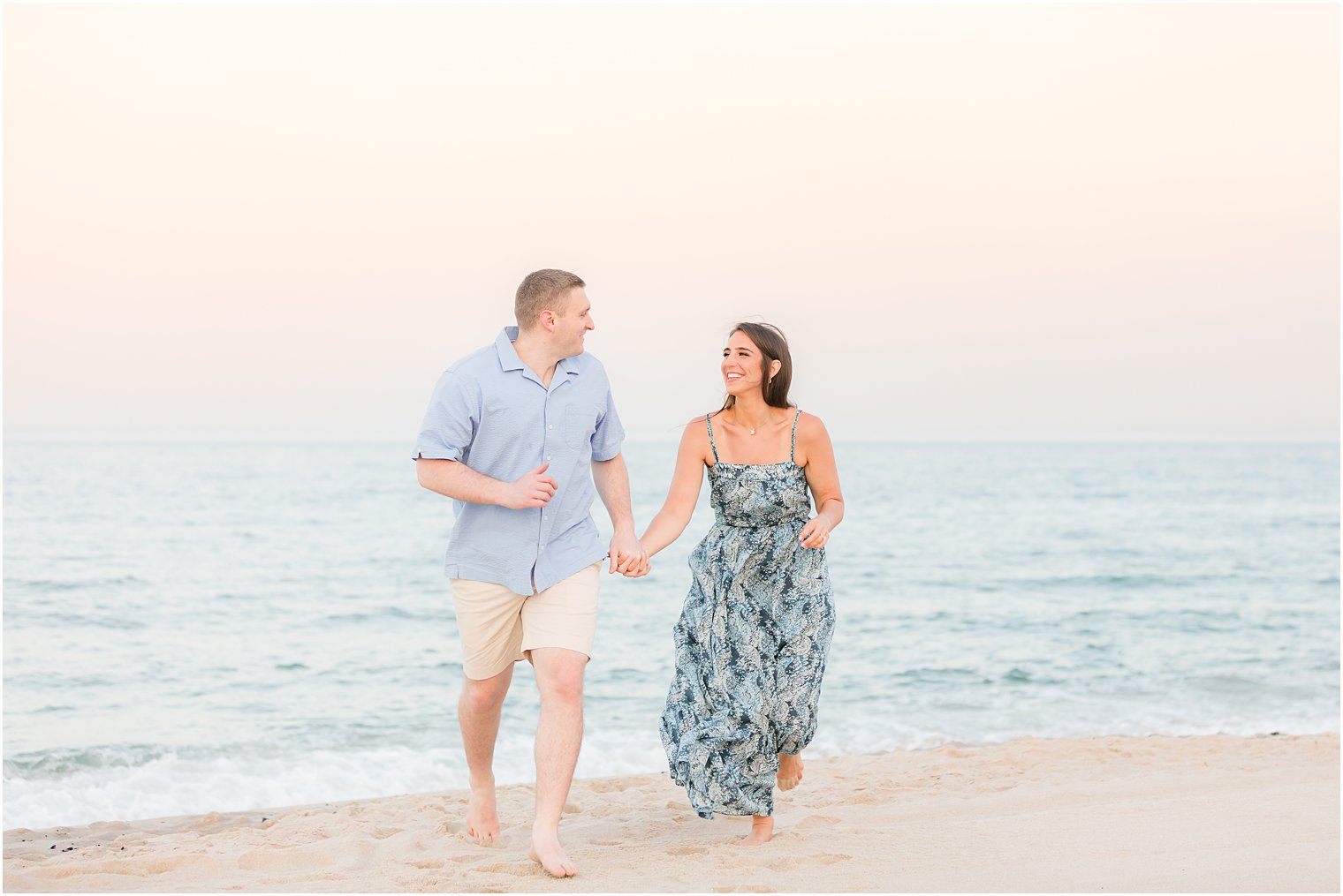 engaged couple walks up beach during NJ photos