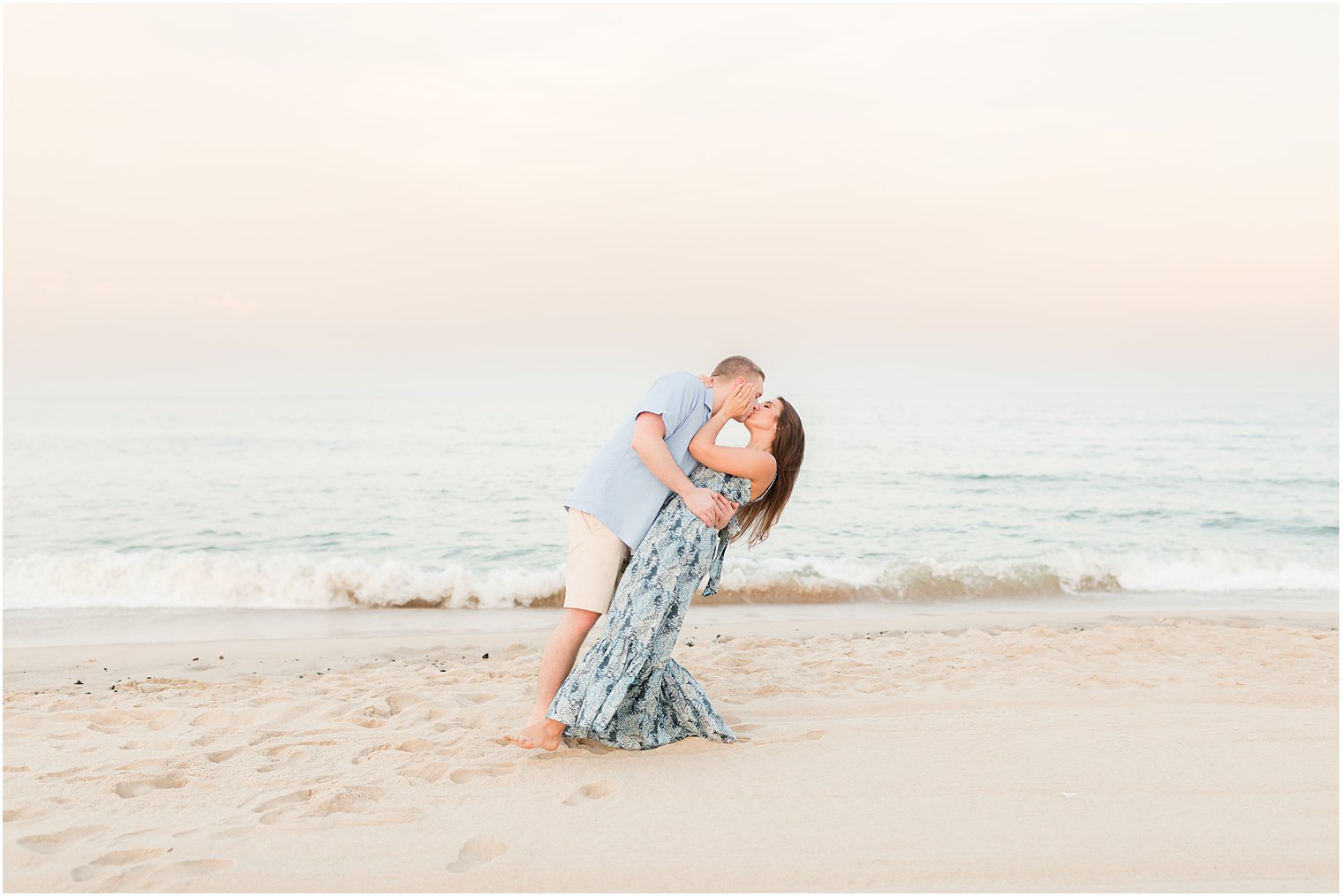 groom dips bride on beach during Spring Lake engagement session