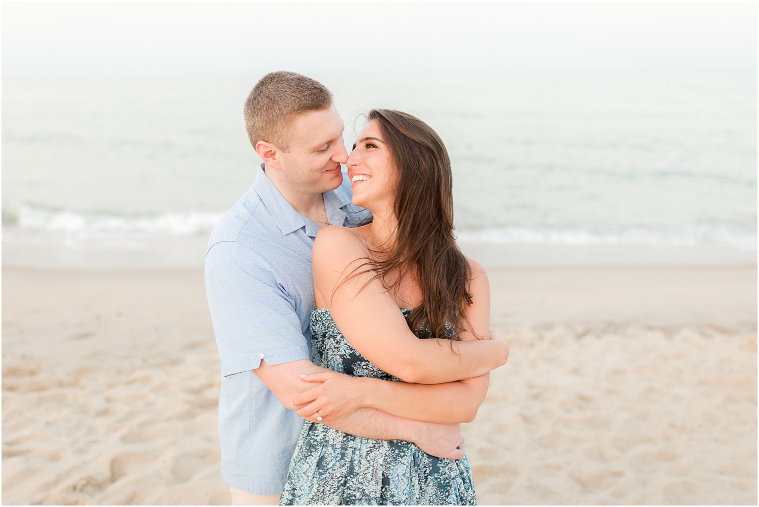 couple hugs on beach during Spring Lake engagement session