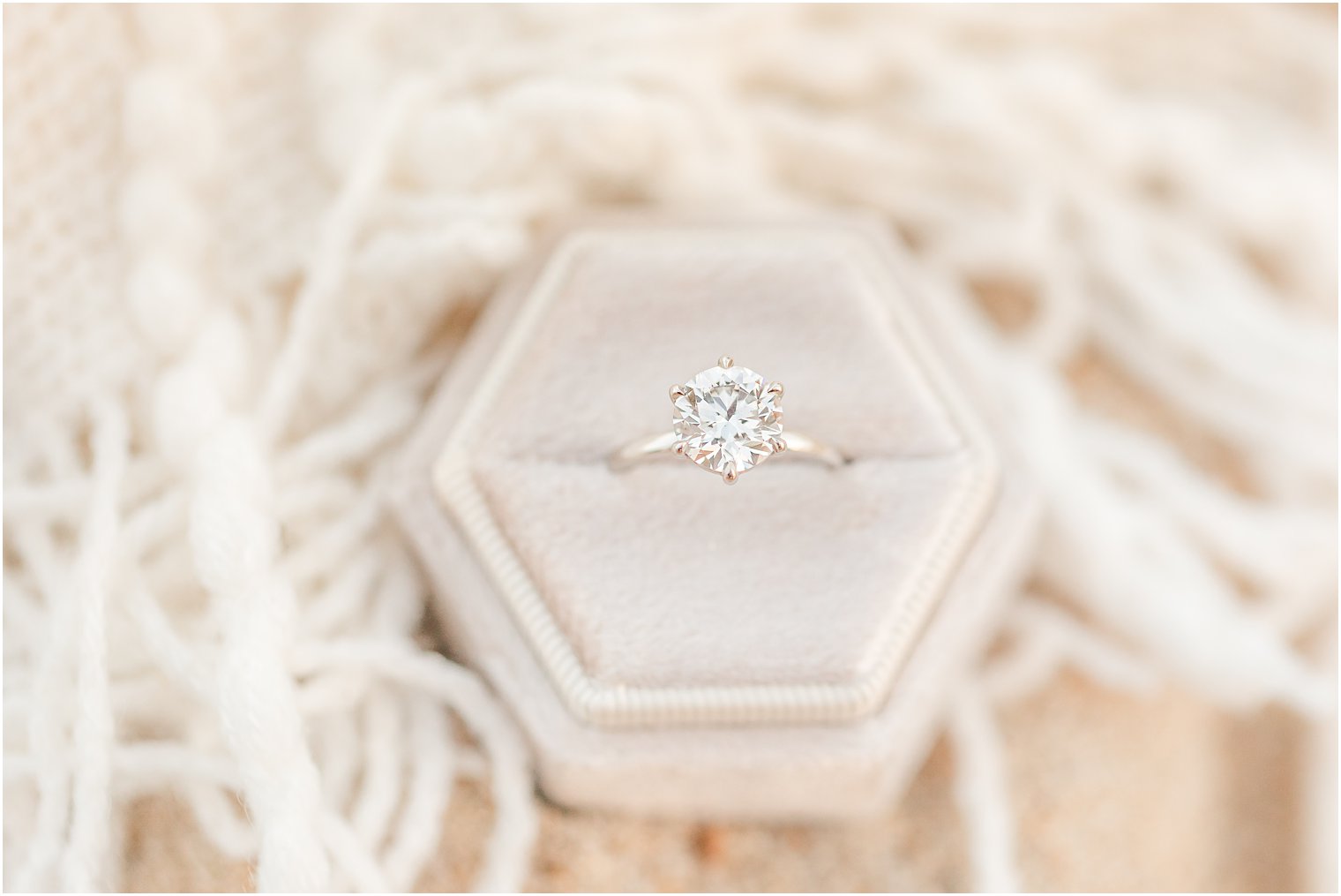 engagement ring rests in macrame holder